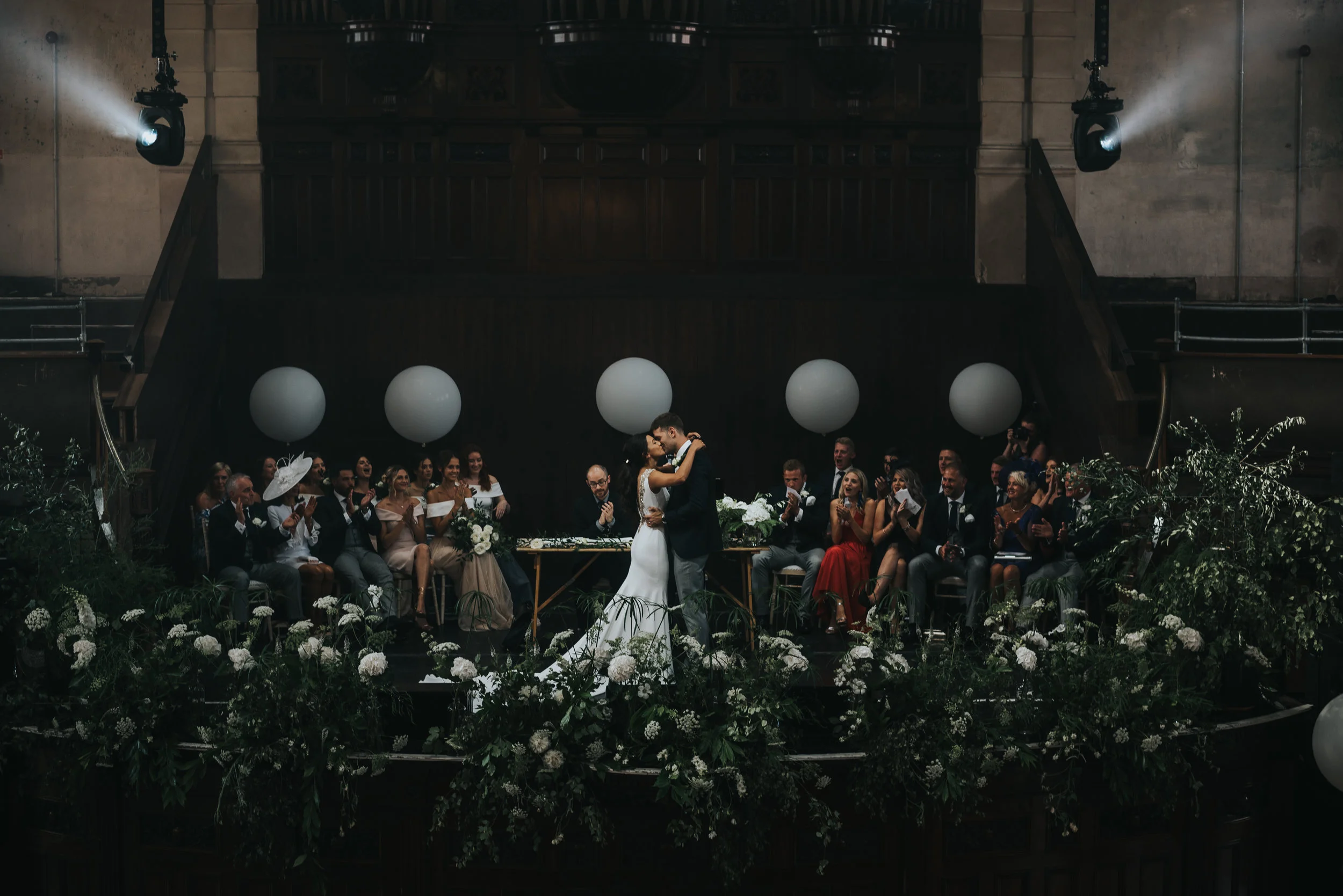 The bride and groom kiss, centre stage at the Albert Hall in front of their friends and family.