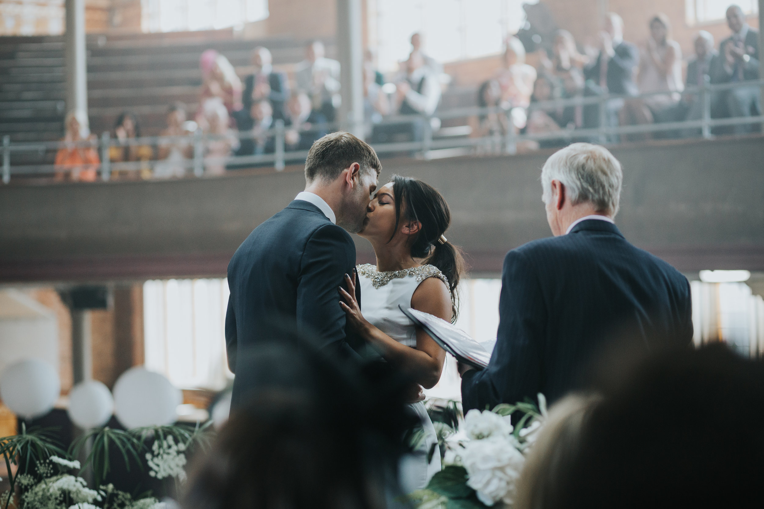 The bride and groom kiss. 