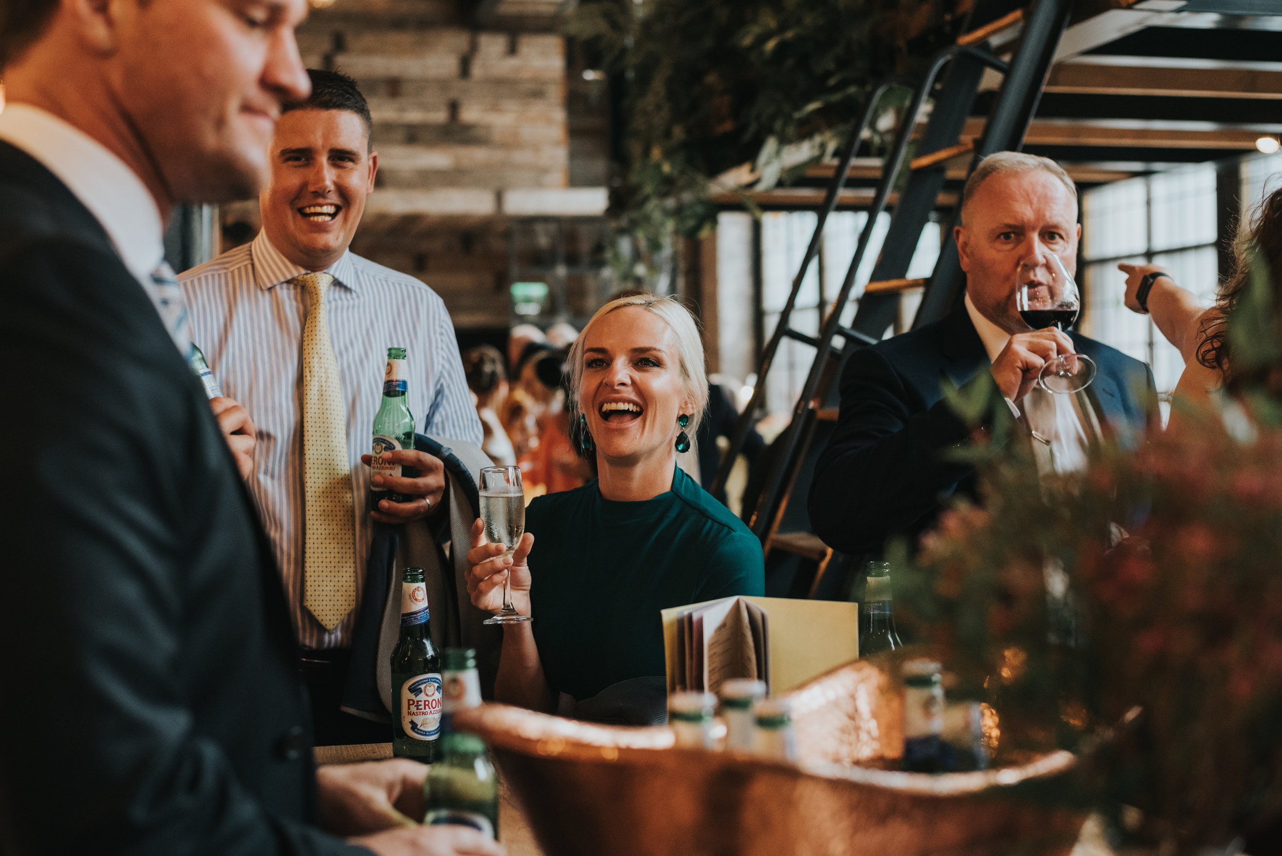 Wedding guests have a drink and laugh together in Albert Schloss. 