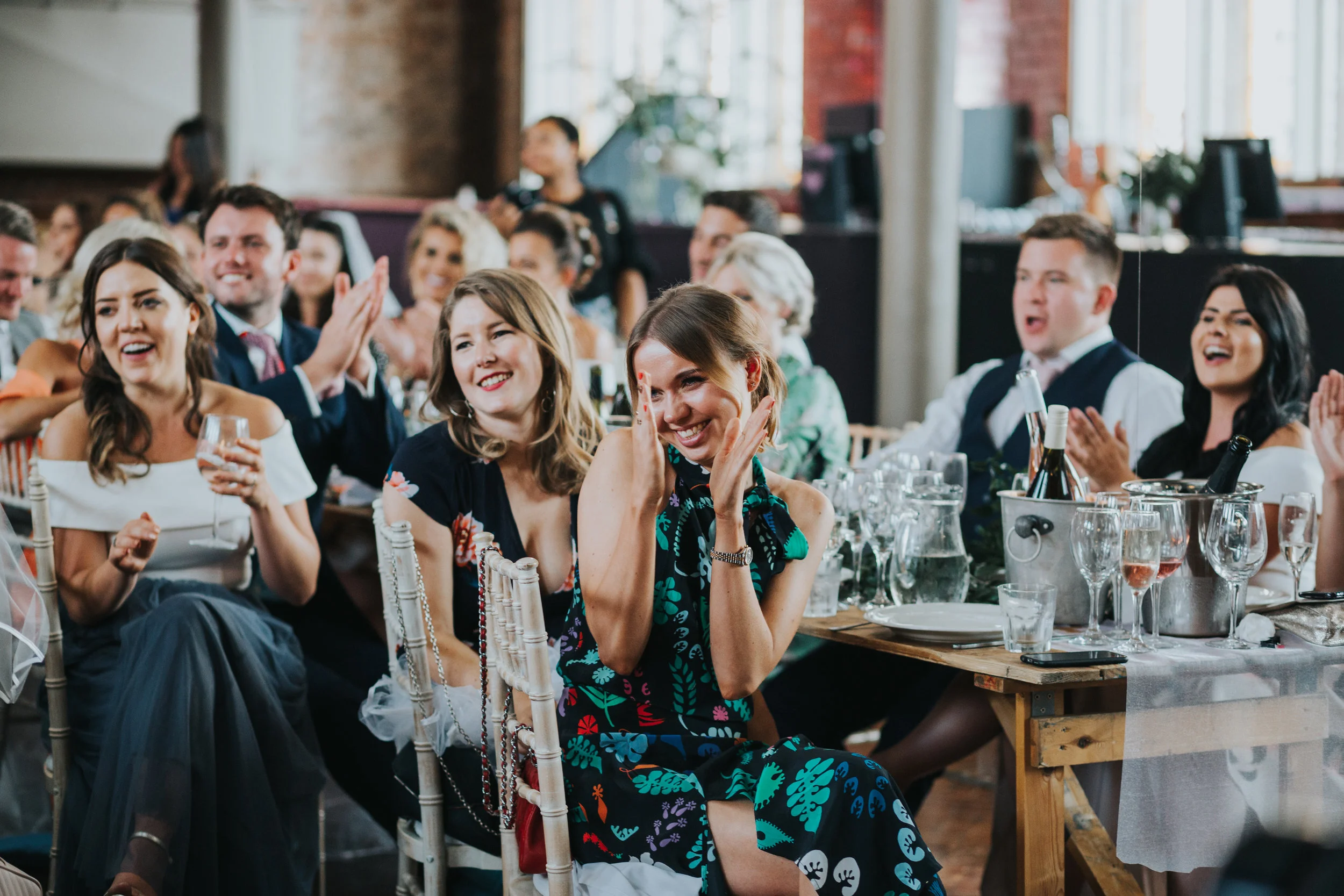 Wedding guests applaud speeches.