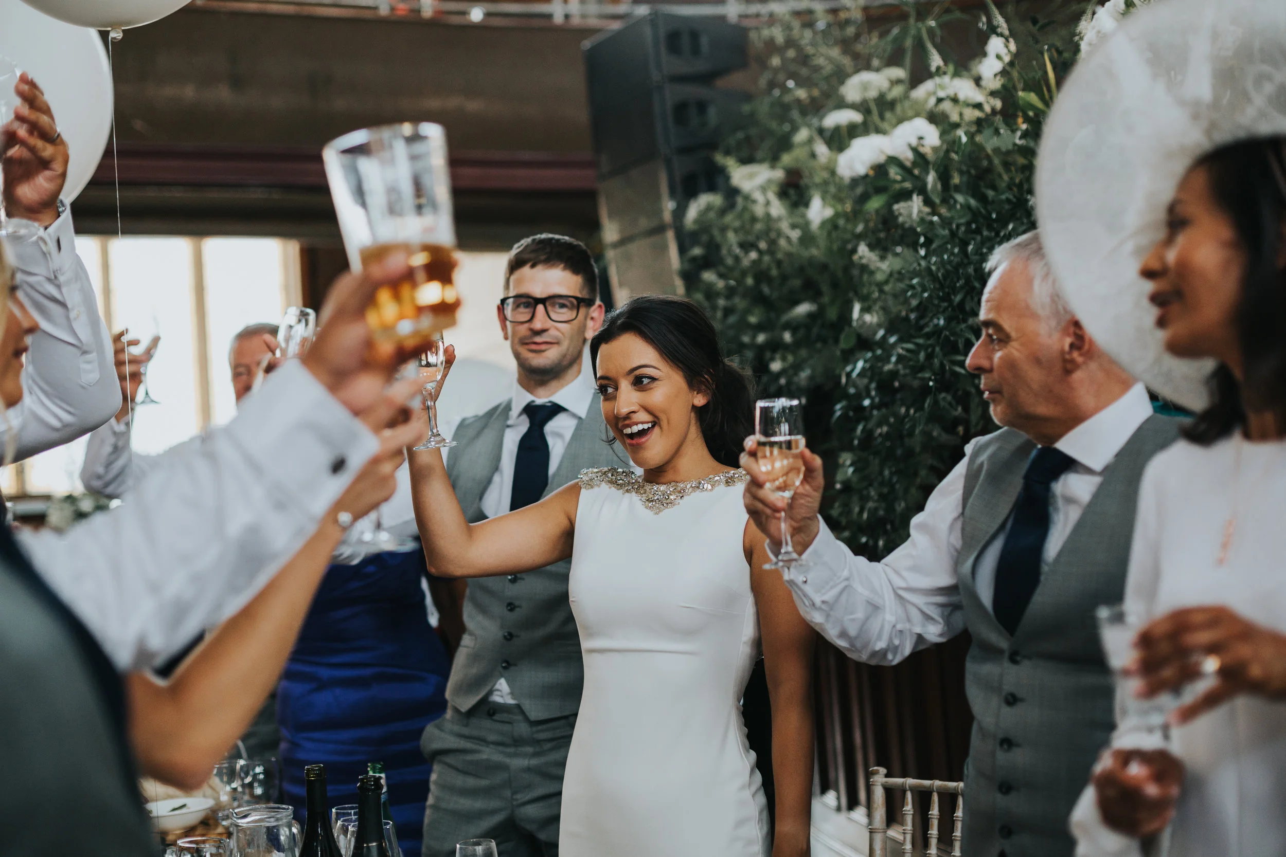 Bride and groom raise their glasses to cheers the best mans speech.