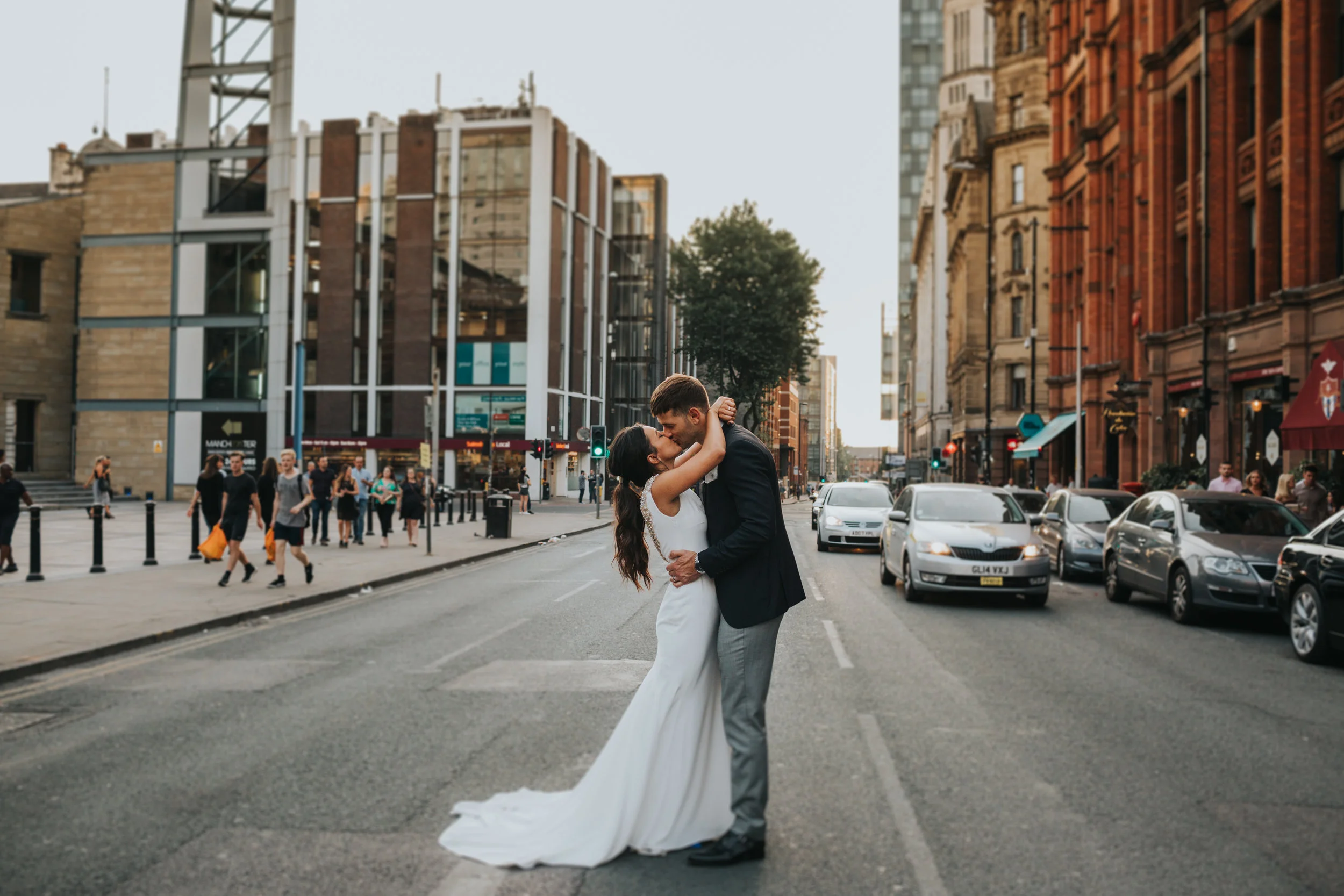Bride and groom kiss in the middle of the road outside the Albert hall, Manchester.