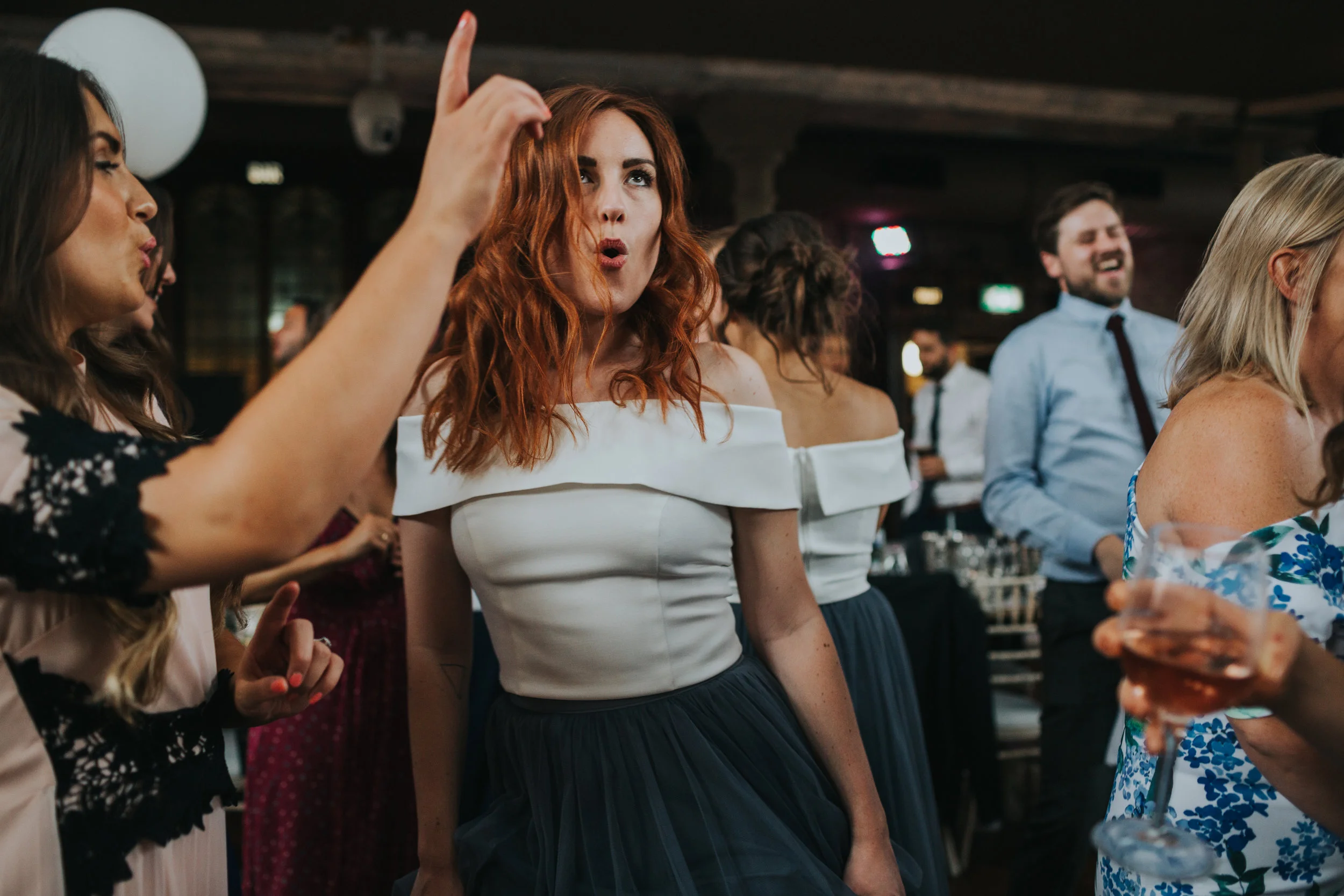 Bridesmaid dancing pulling a funny face.
