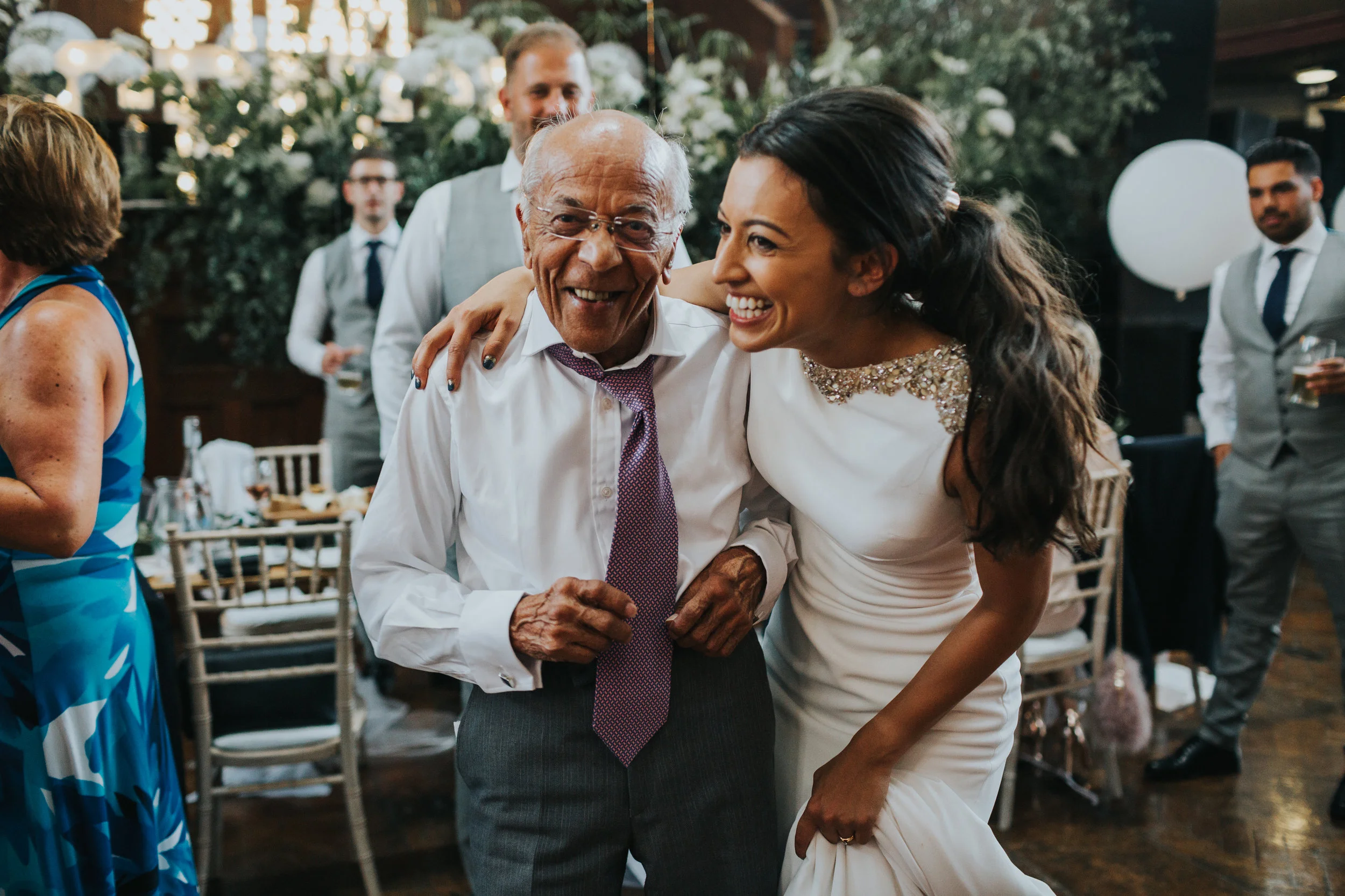 Bride and grandad laugh together at the Albert Hall Manchester.