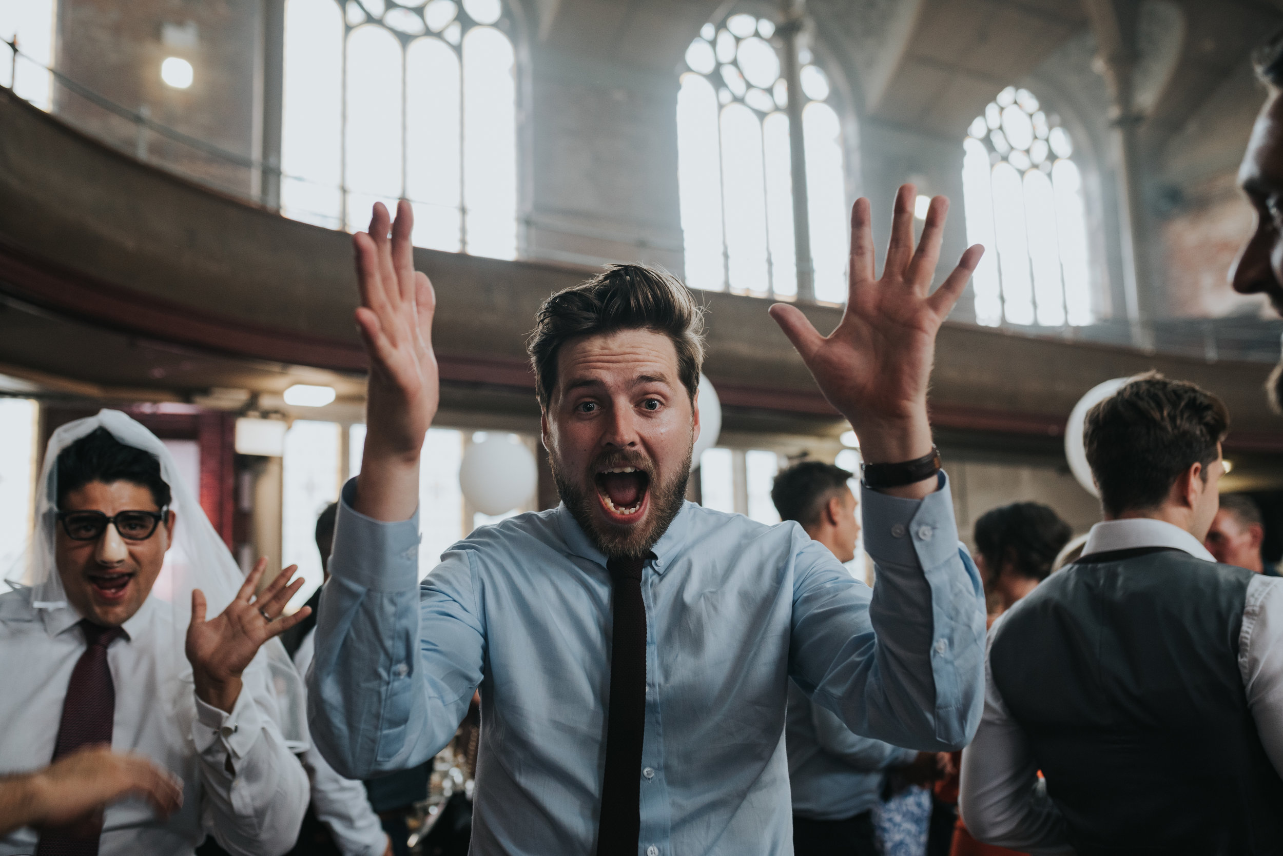 Wedding guest with shocked face and hands in the air. 