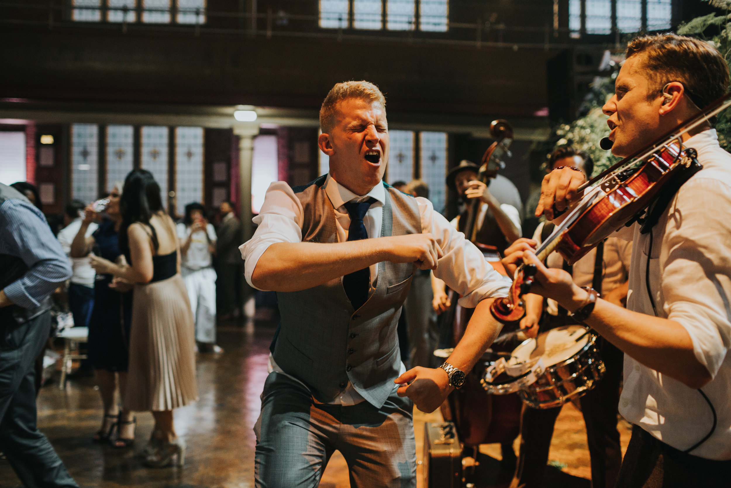 Best man dancing in front of the band. 