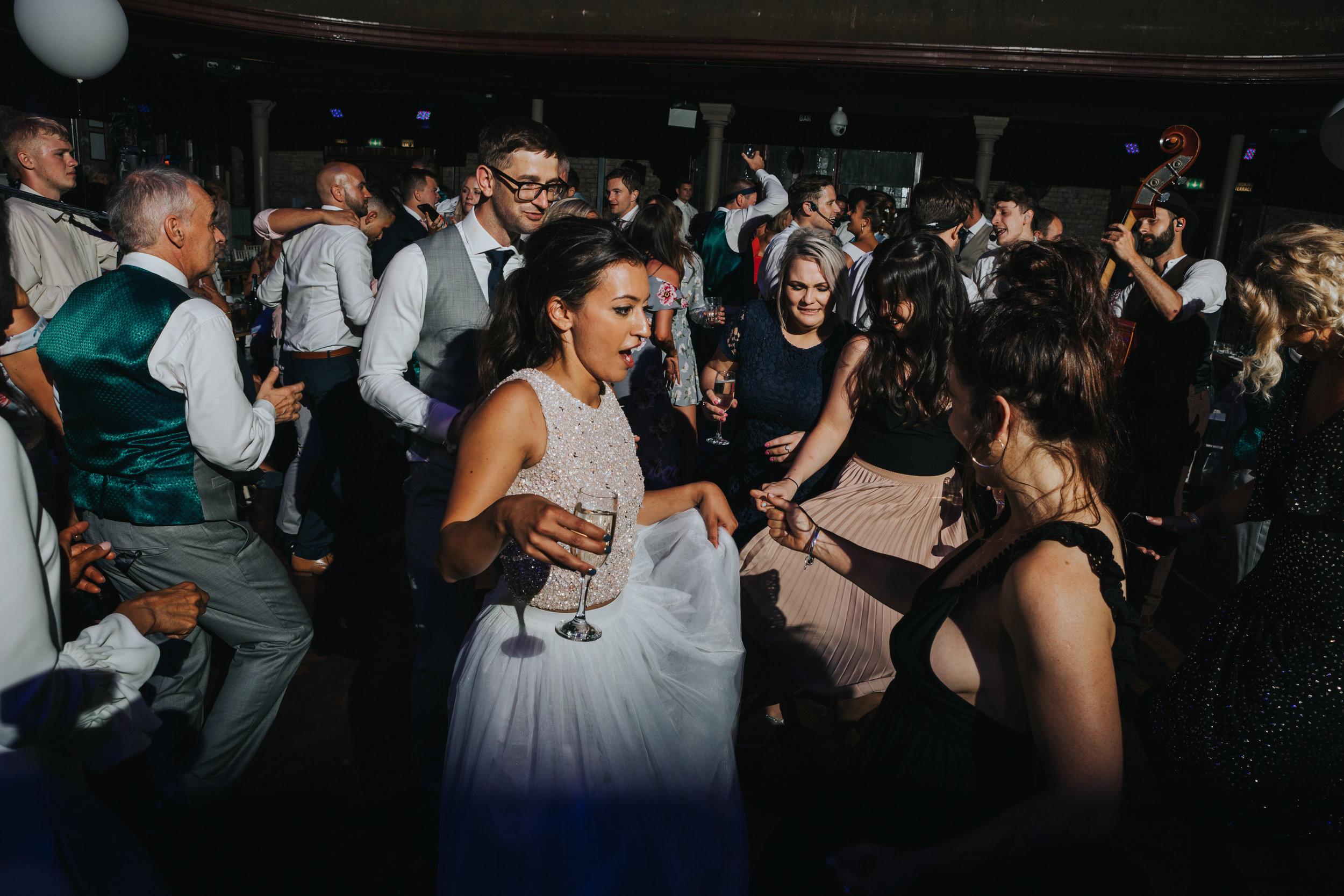 Bride dances in the middle of her friends swishing her skirt around. 