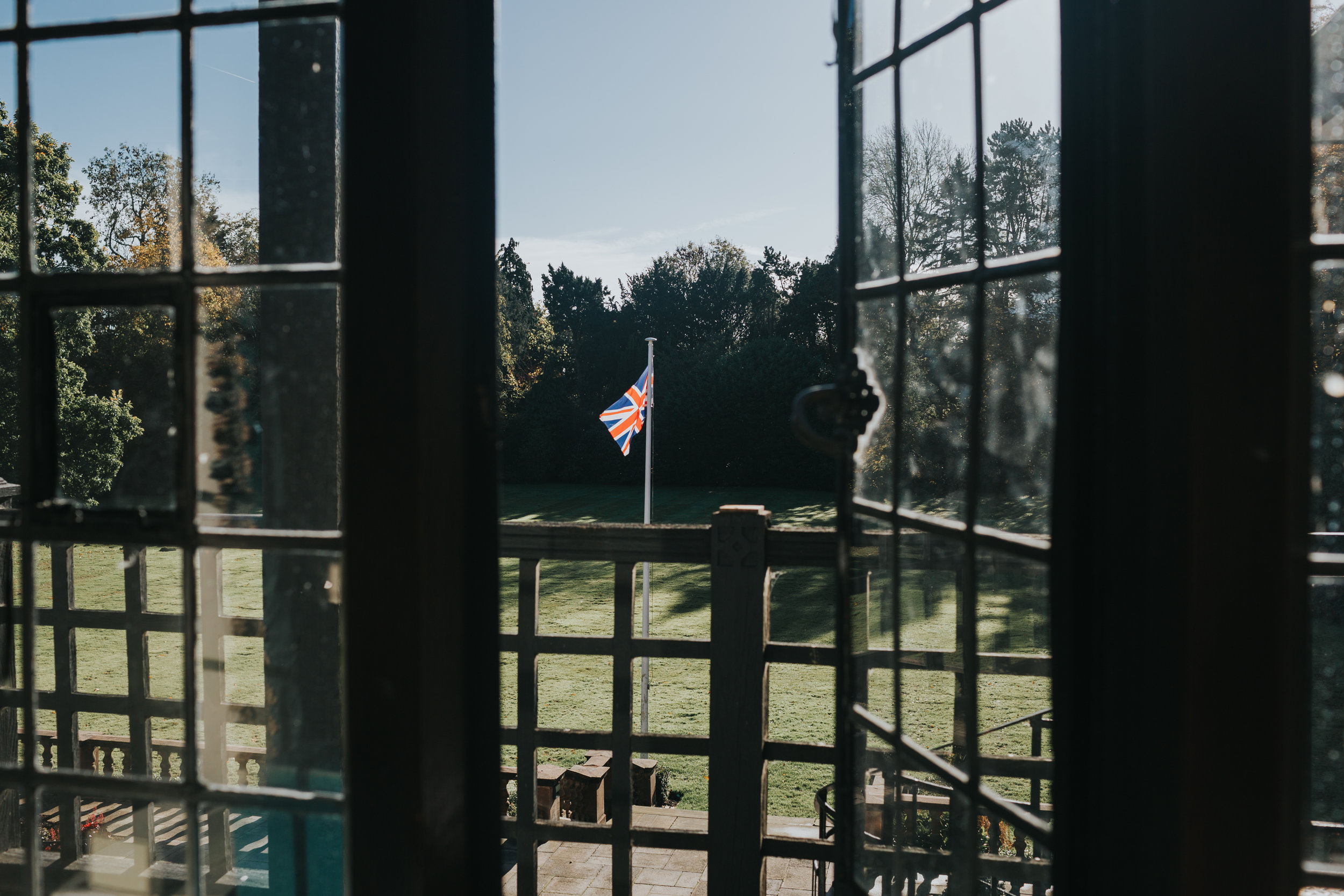 The Union Jack flies outside the hotel room window at Inglewood Manor, the sun is shining. 