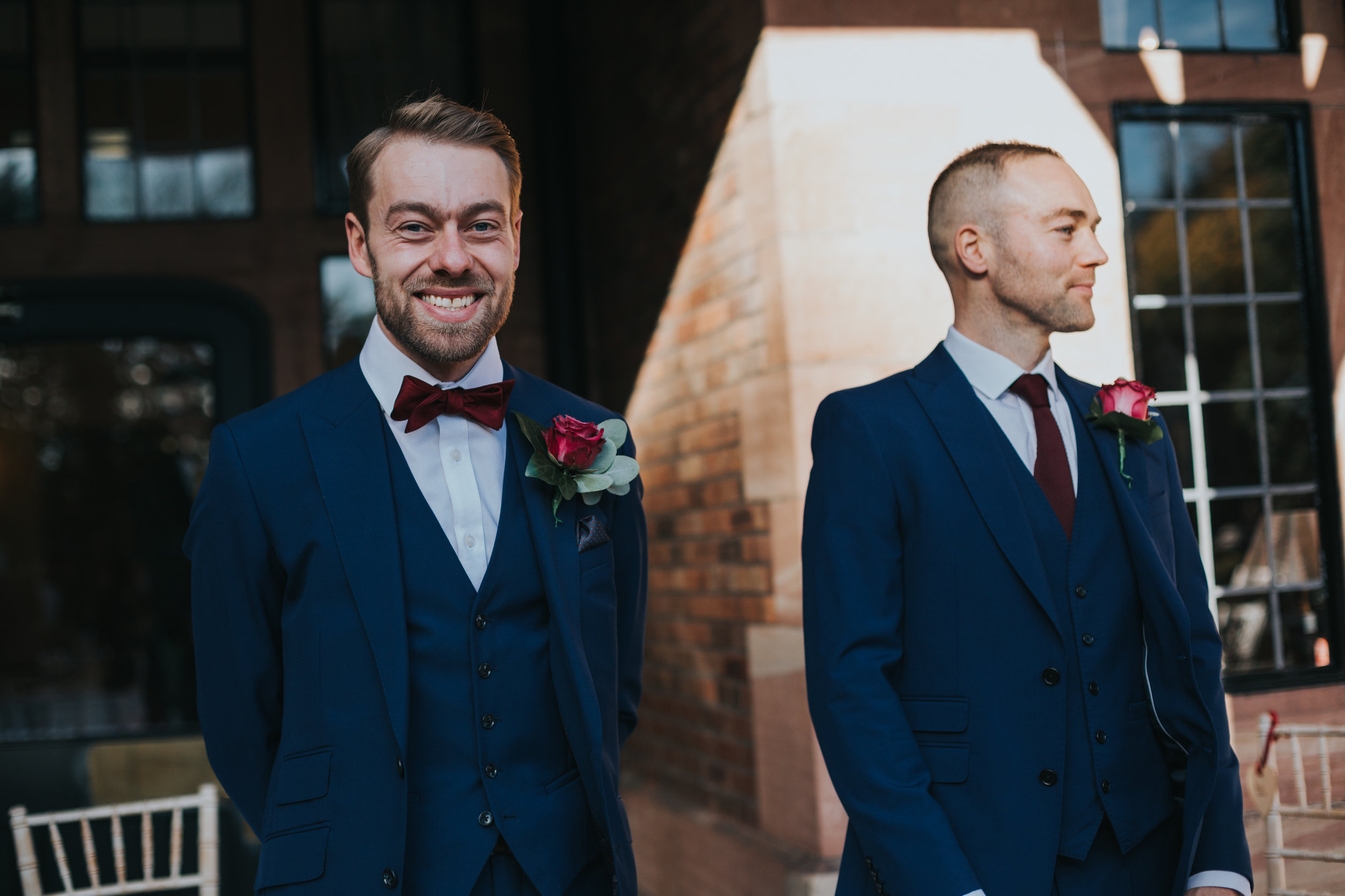 The groom and his best man stand smiling awaiting their guests at their outdoor ceremony at Inglewood Manor. 