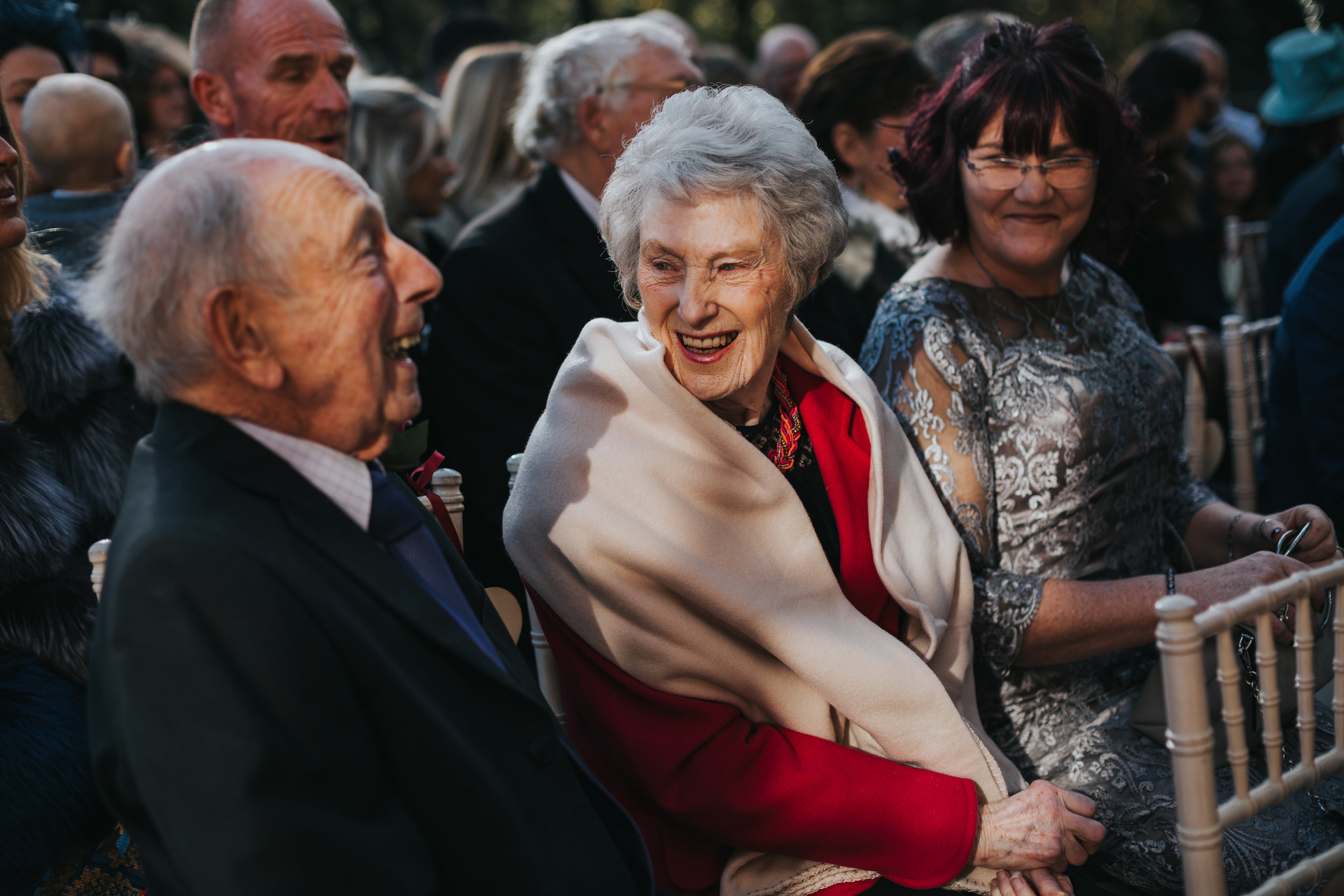 Grandparents laugh together in the sunlight. 