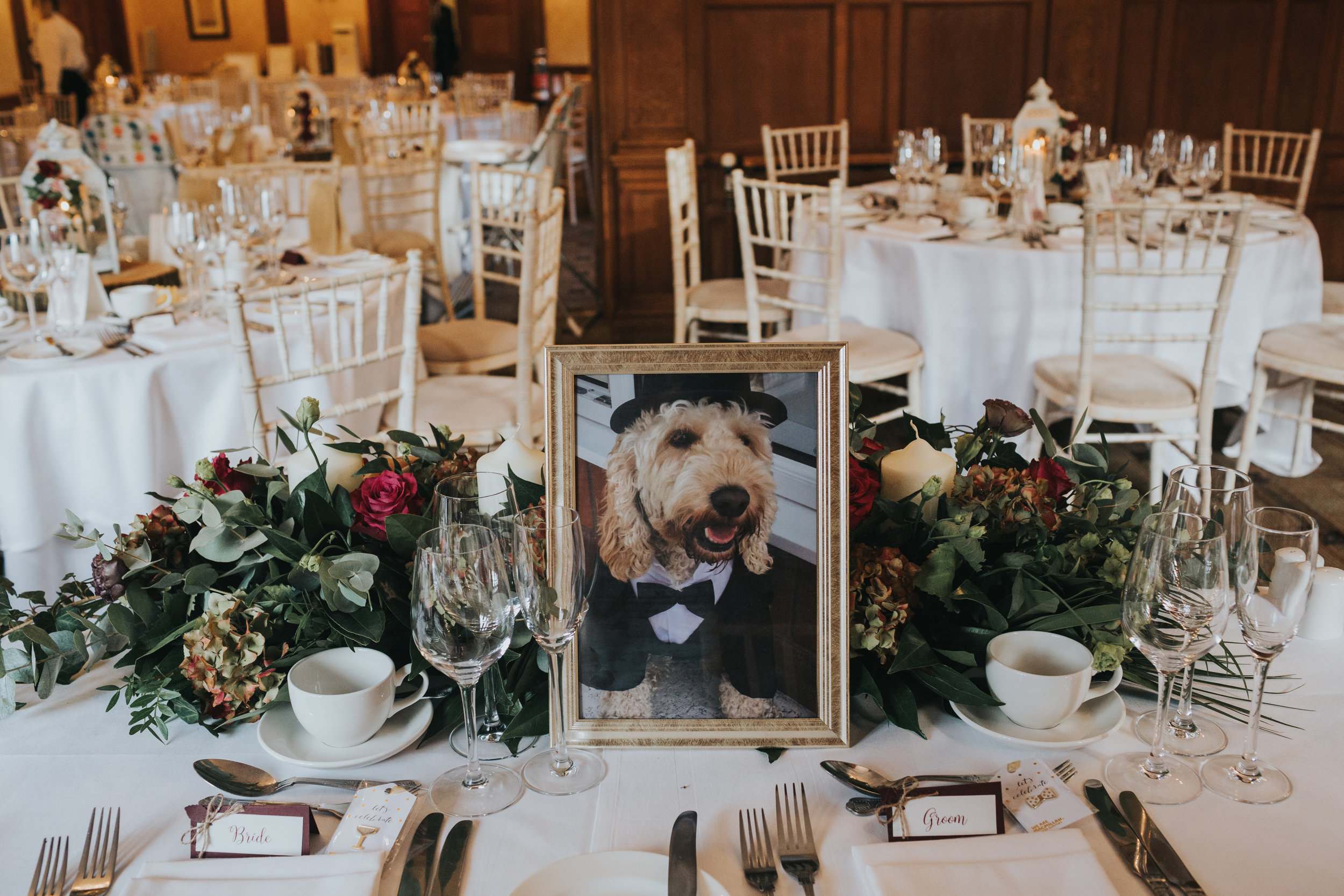 A photograph of the bride and grooms dog awaits them at their table.