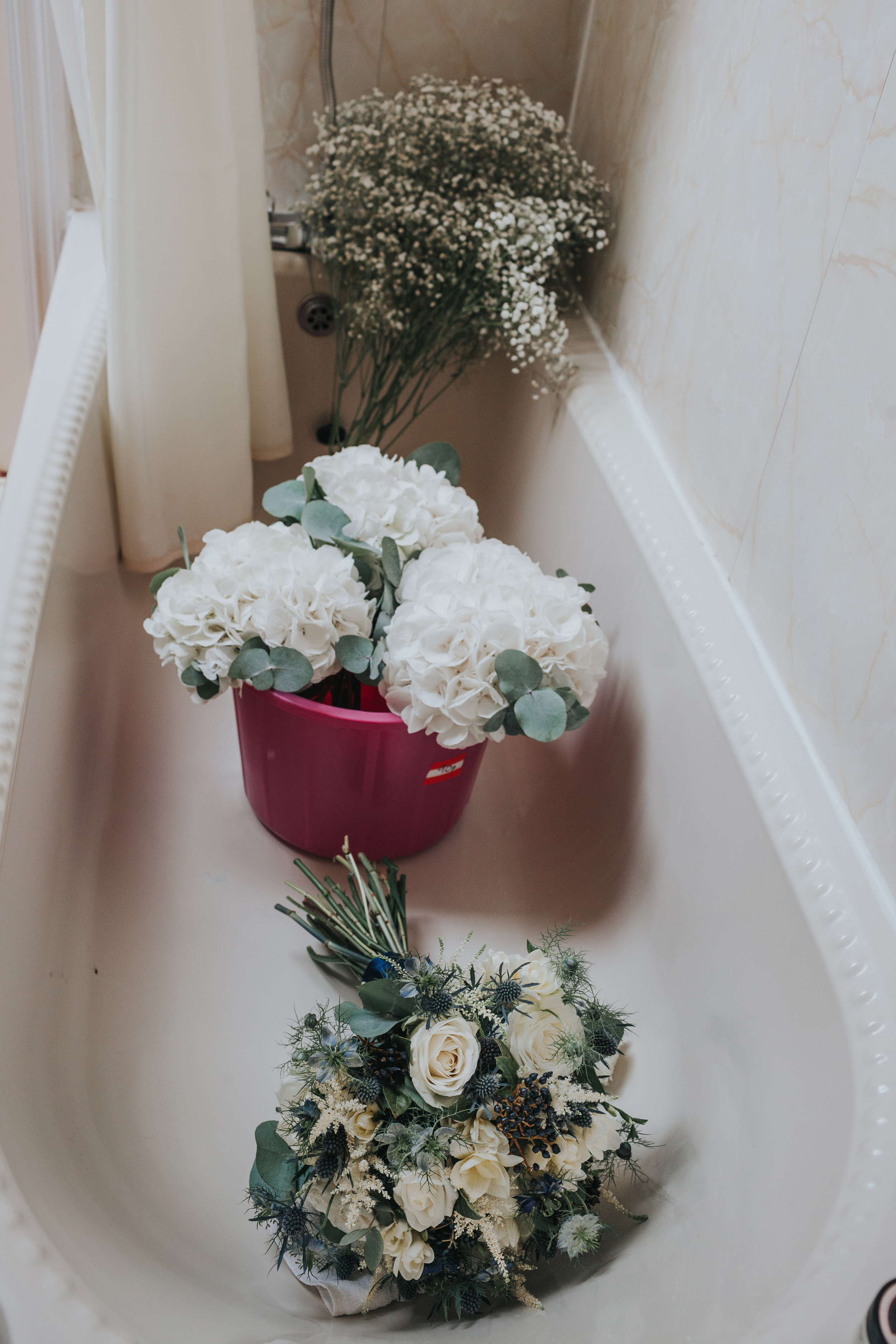Wedding flowers lined up in the bath.