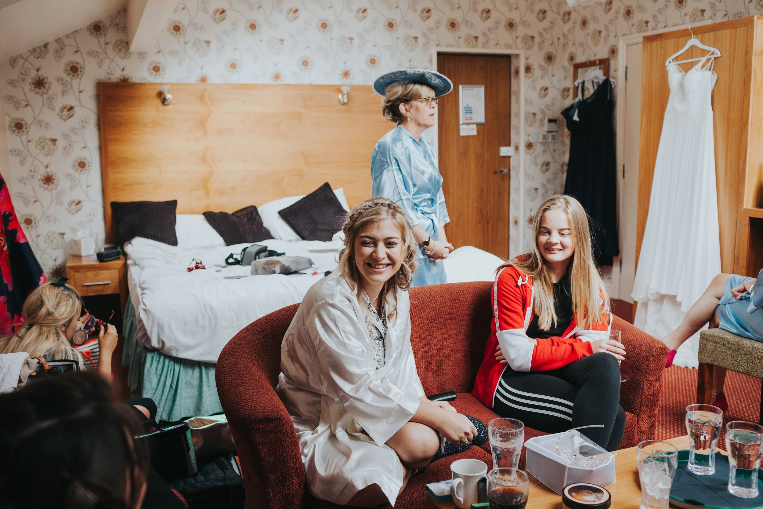 Girls smiling with wedding dress in background. 