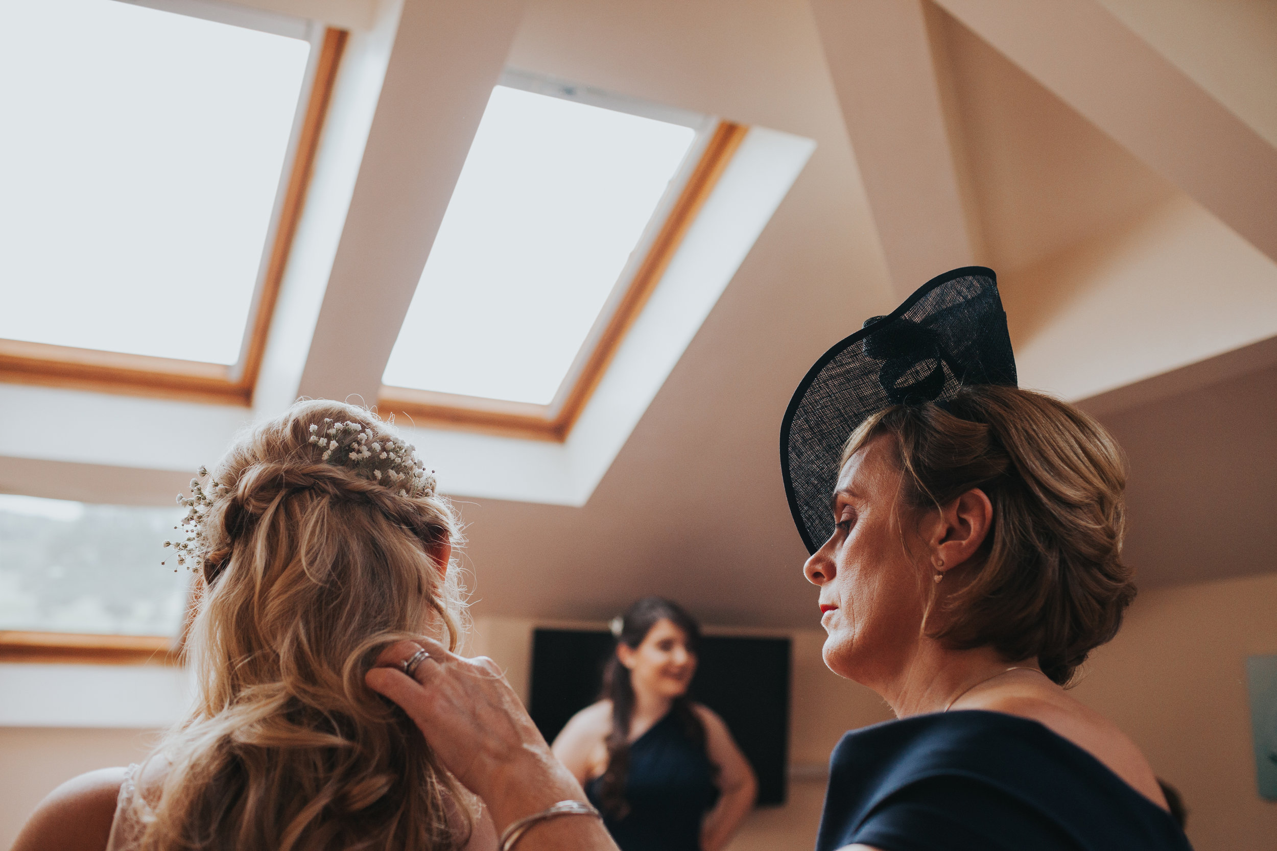 Mother of the bride fixes her daughters hair. 