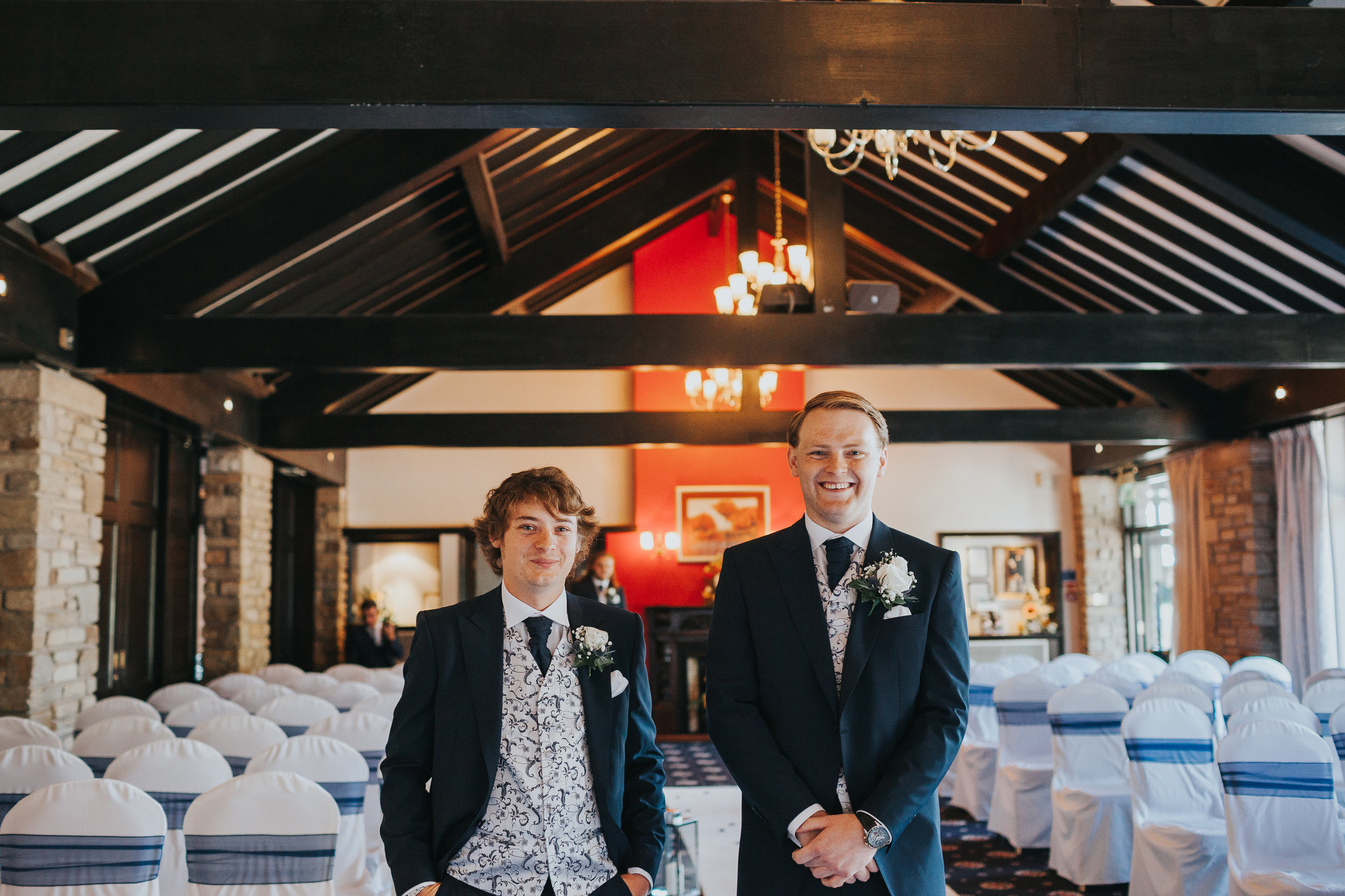 Groom and his best man smile together. 