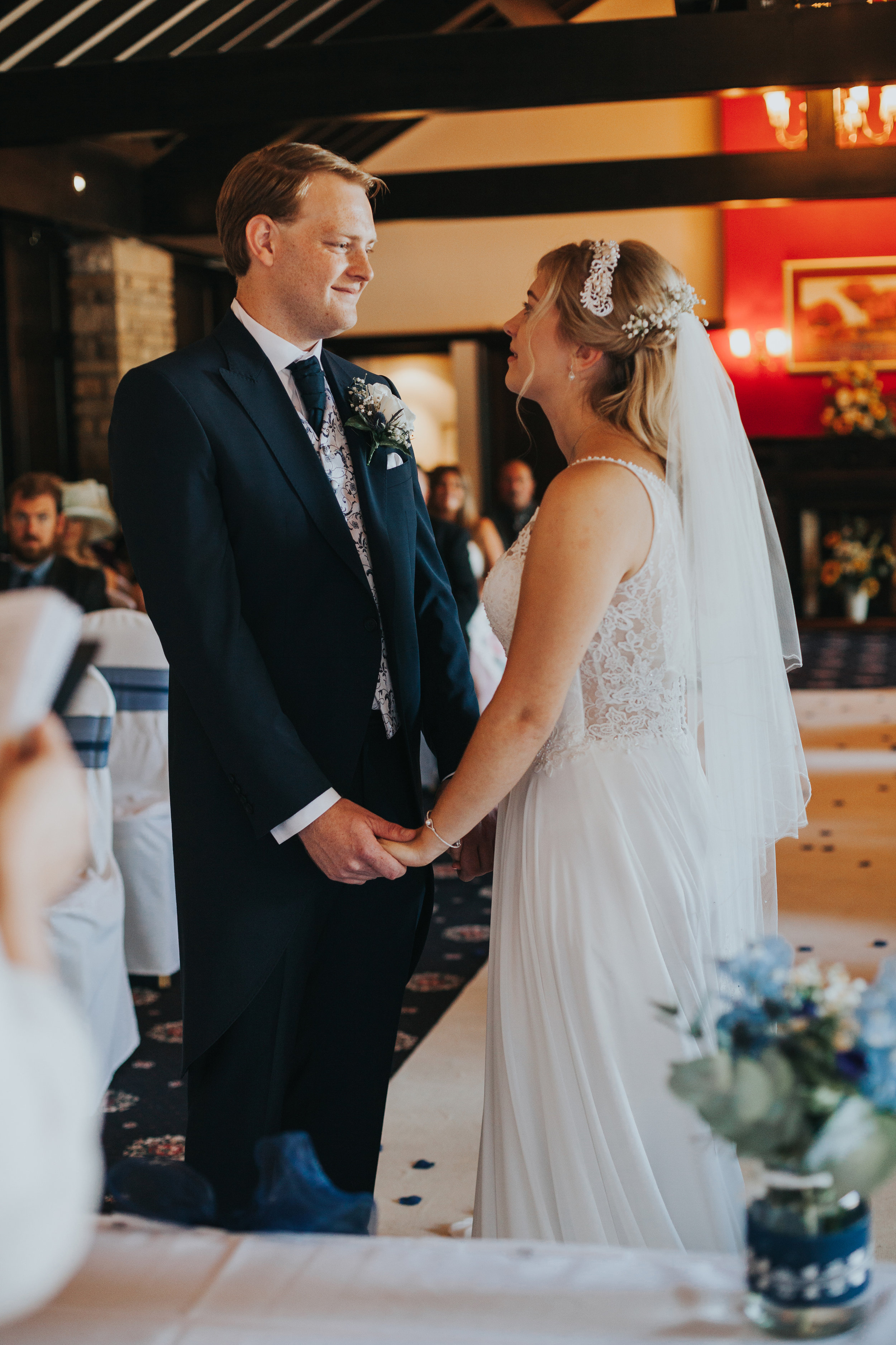 Bride and groom hold hands.