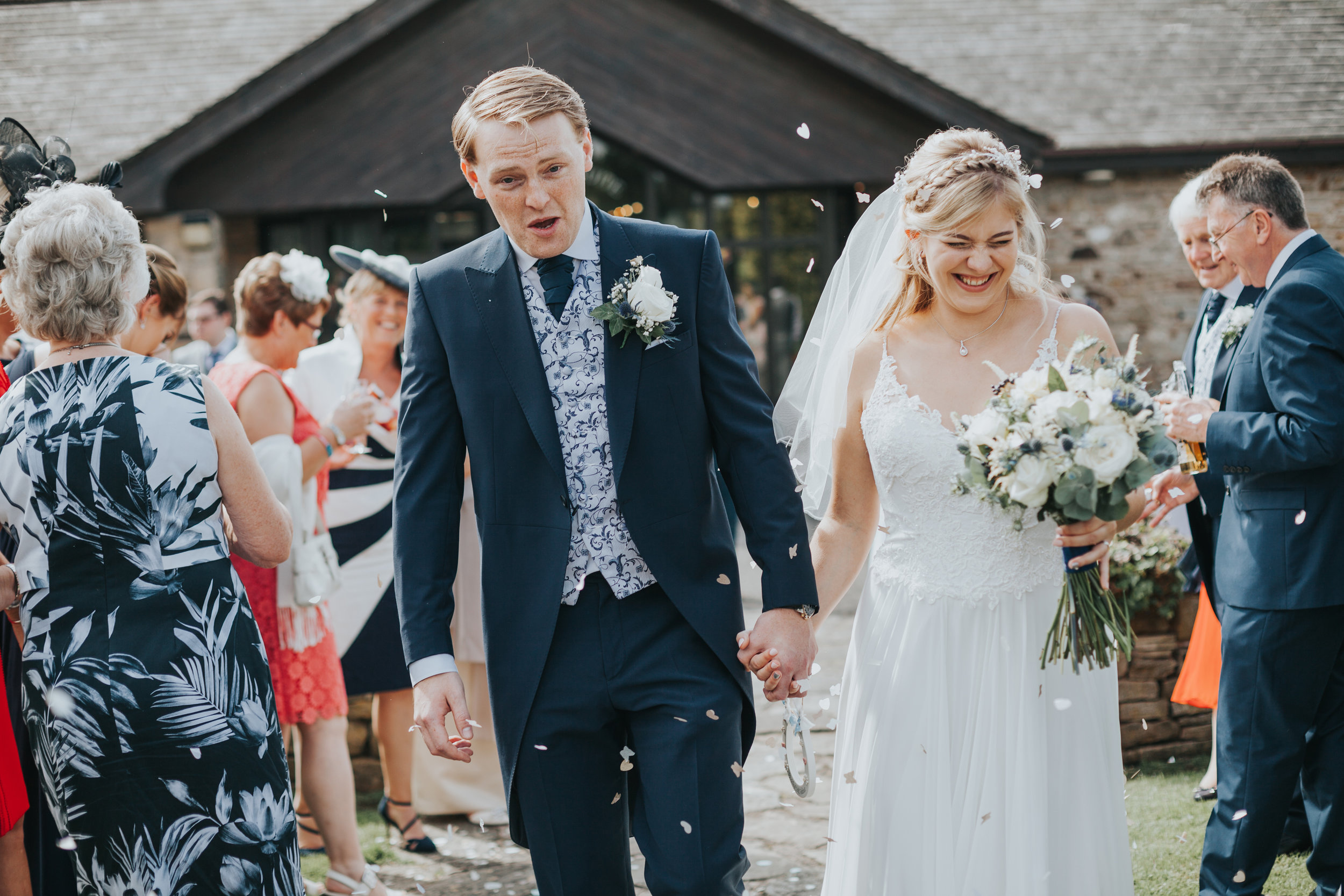 Bride and groom have confetti thrown at them outside the ceremony room at Mytton Fold. 