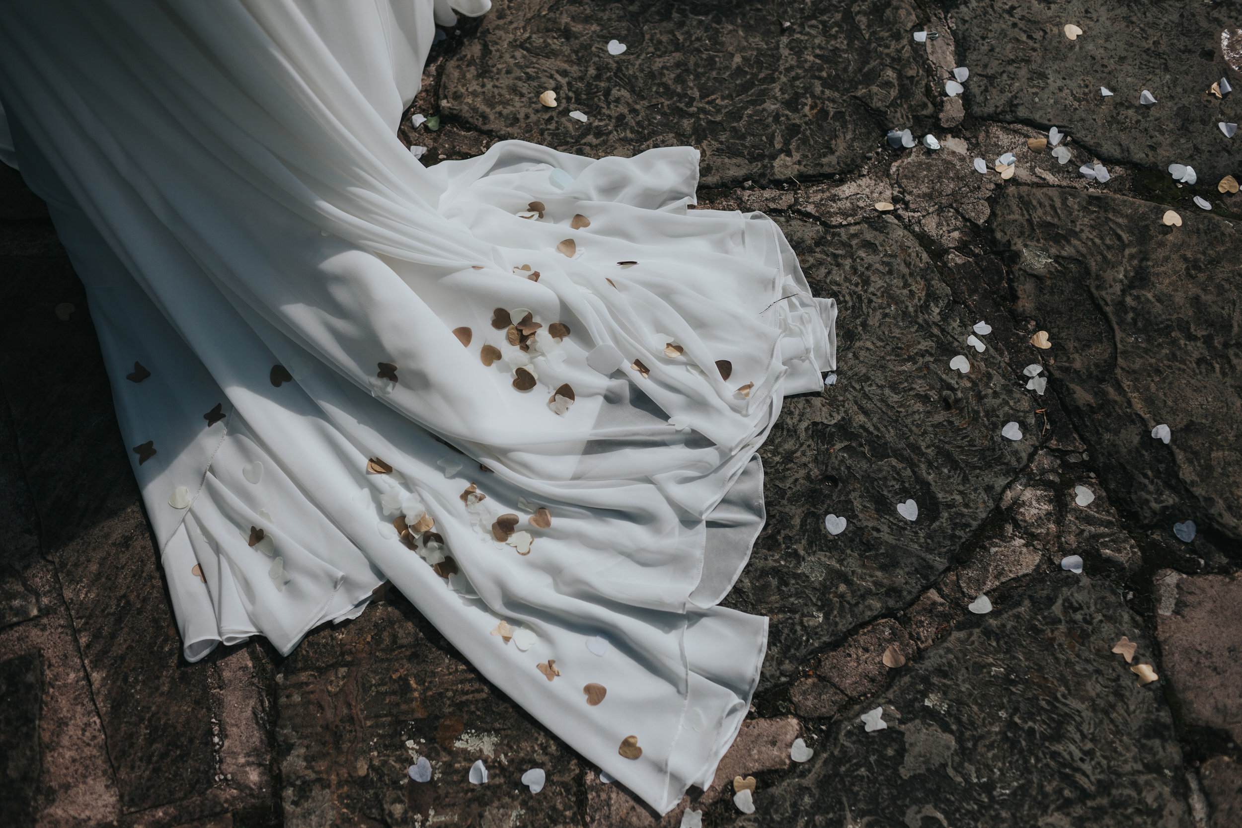 The trail of the Brides wedding dress is covered in heart shaped confetti.