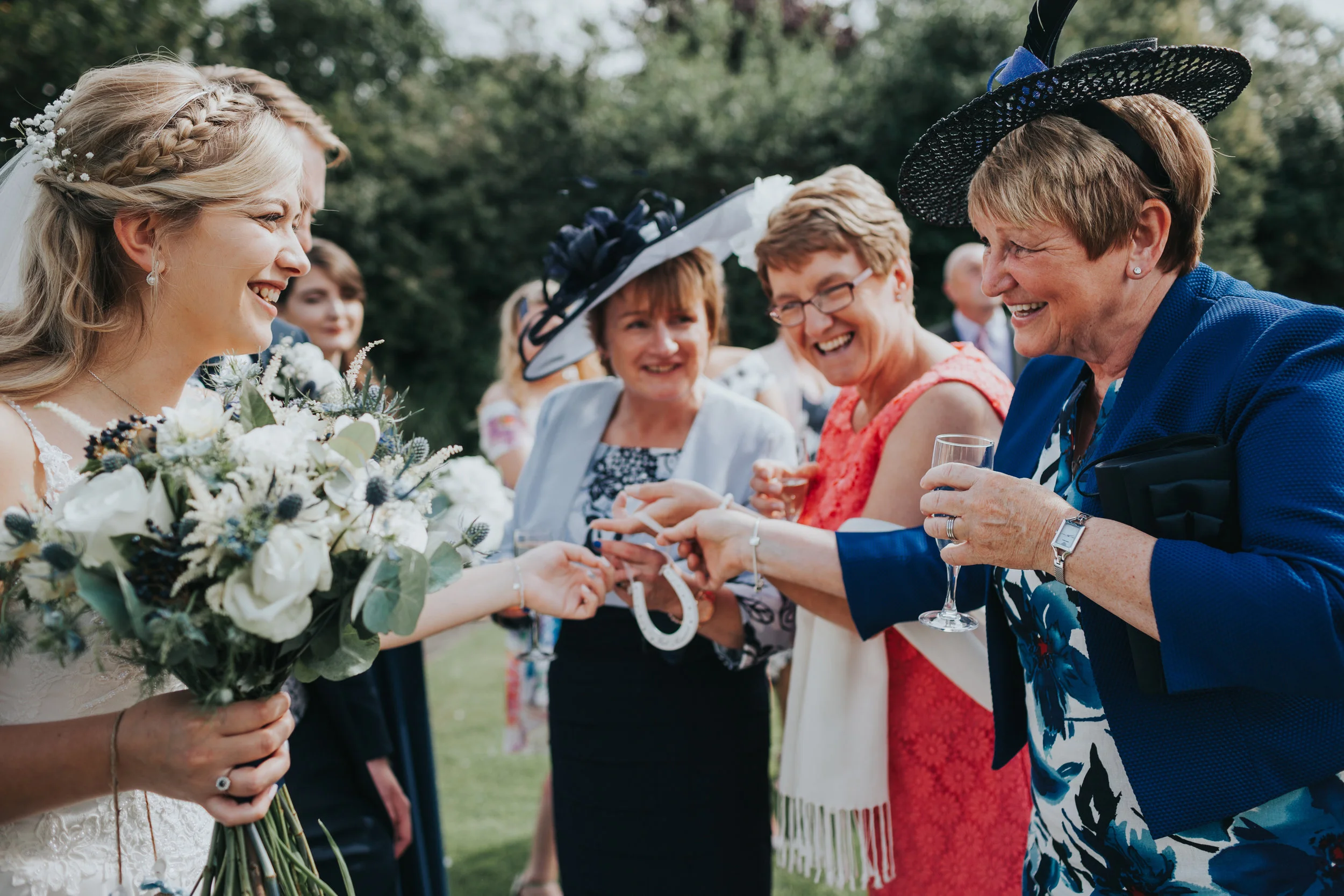 Bride is presented a horse shoe by wedding guests. 