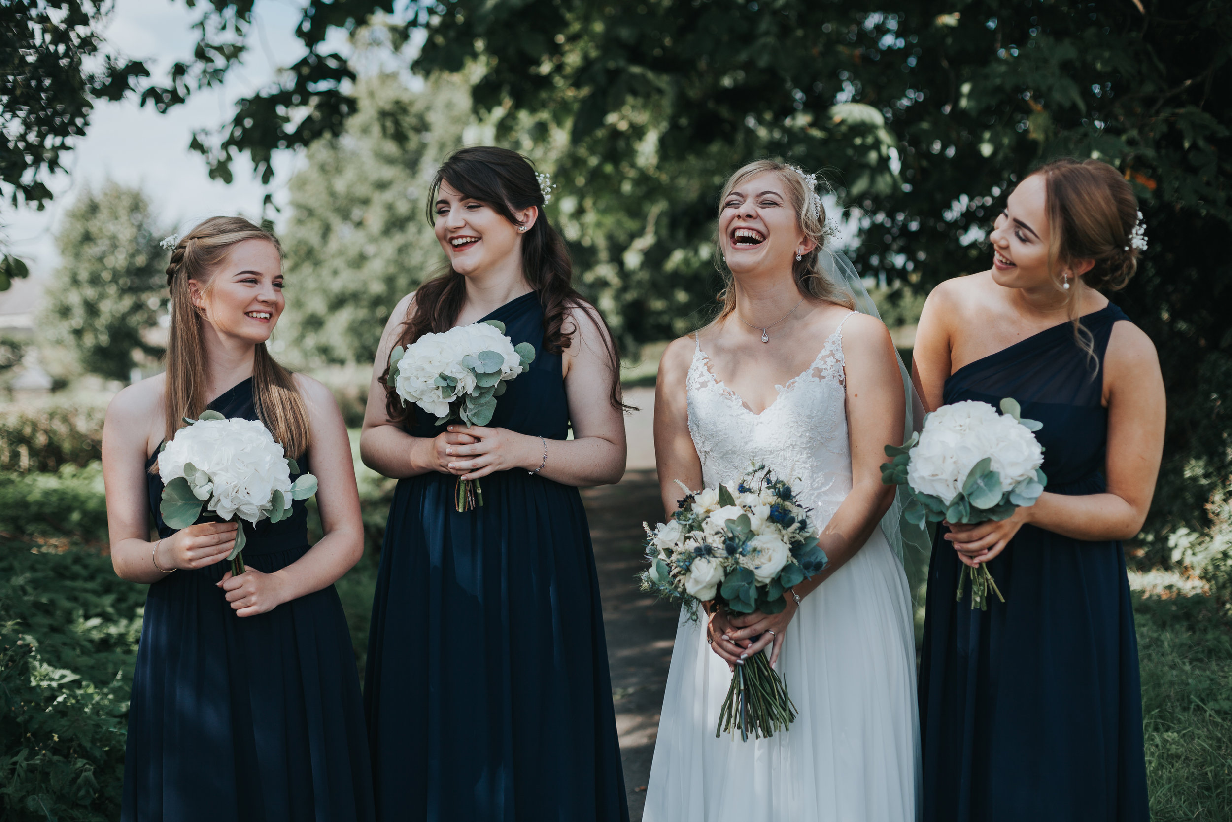 Bride laughs with bridesmaids. 