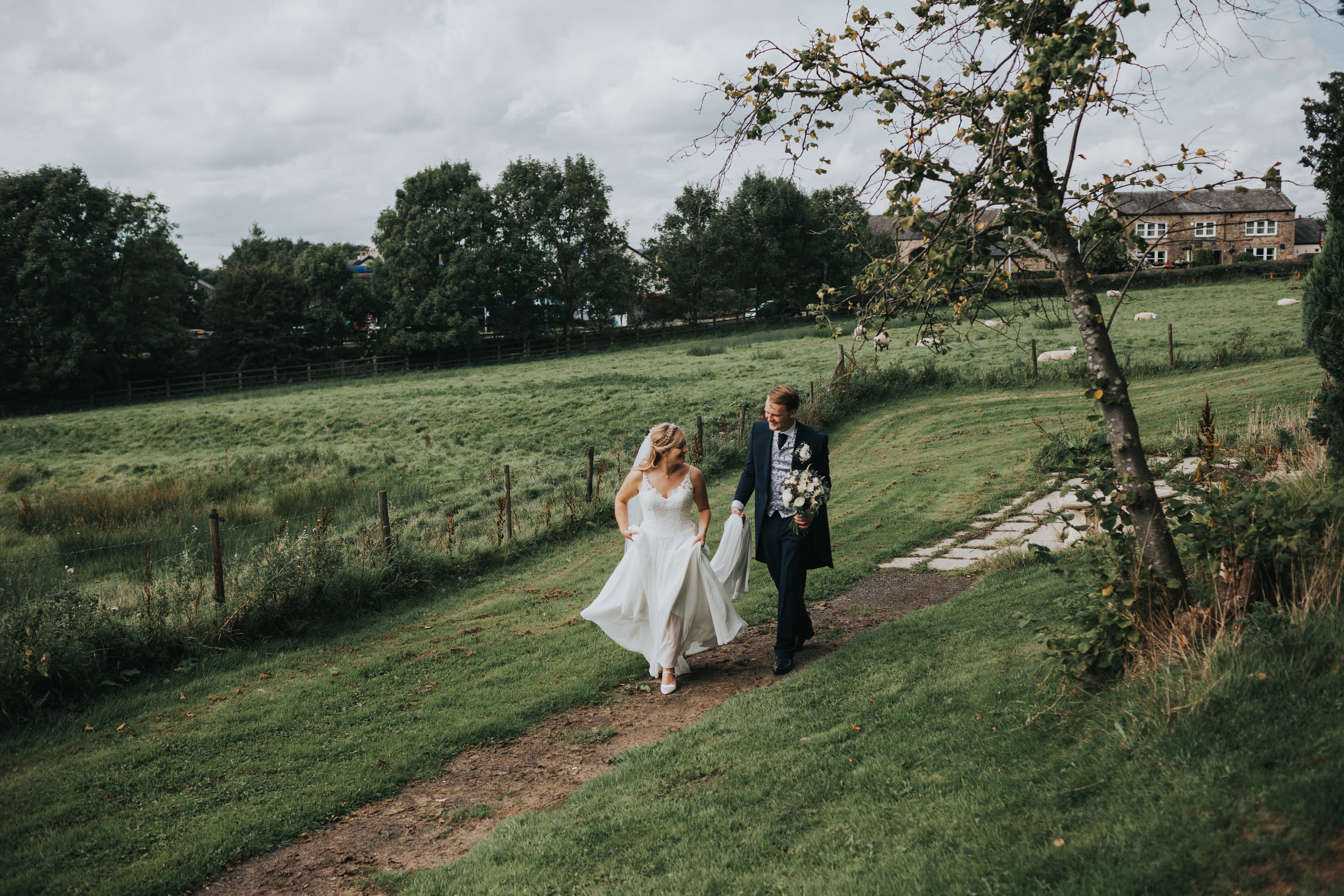 Bride and Groom take a walk down a dirt path.