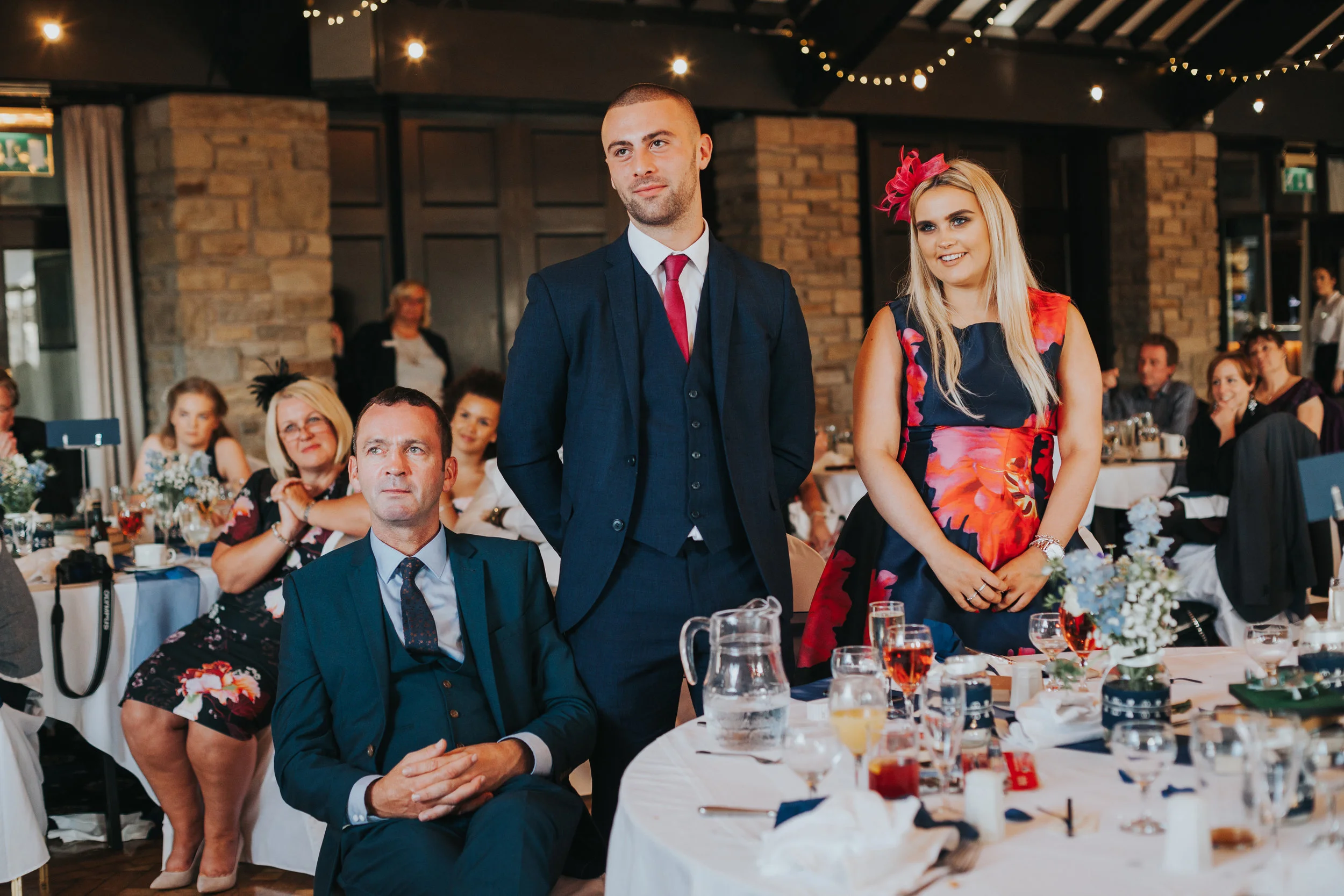 Wedding guests stand teary eyed during speeches. 
