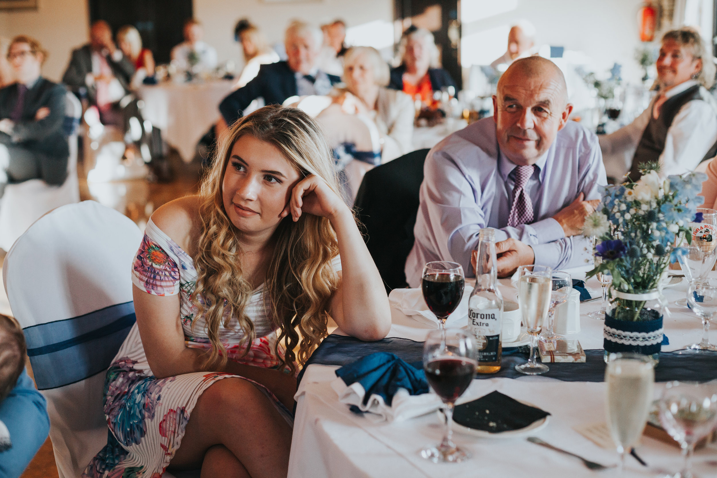 Wedding guests sit enjoying speeches. 