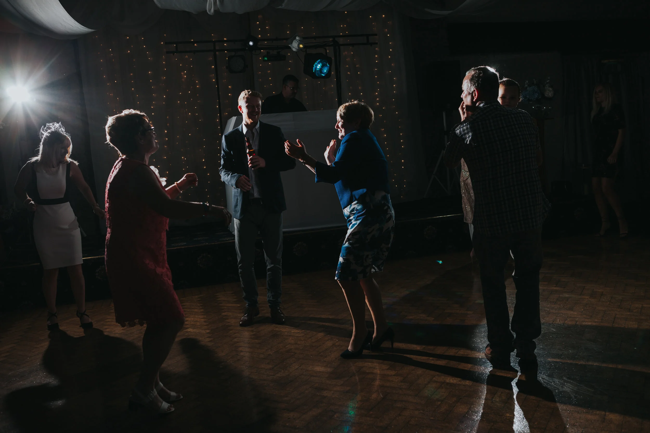 Wedding guests make shapes on the dance floor. 