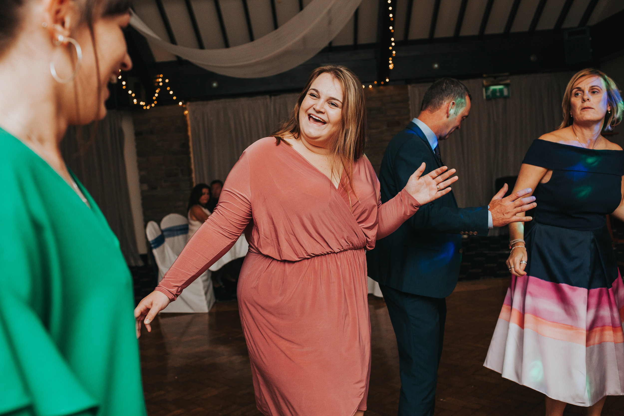 Wedding guest smiles while dancing.