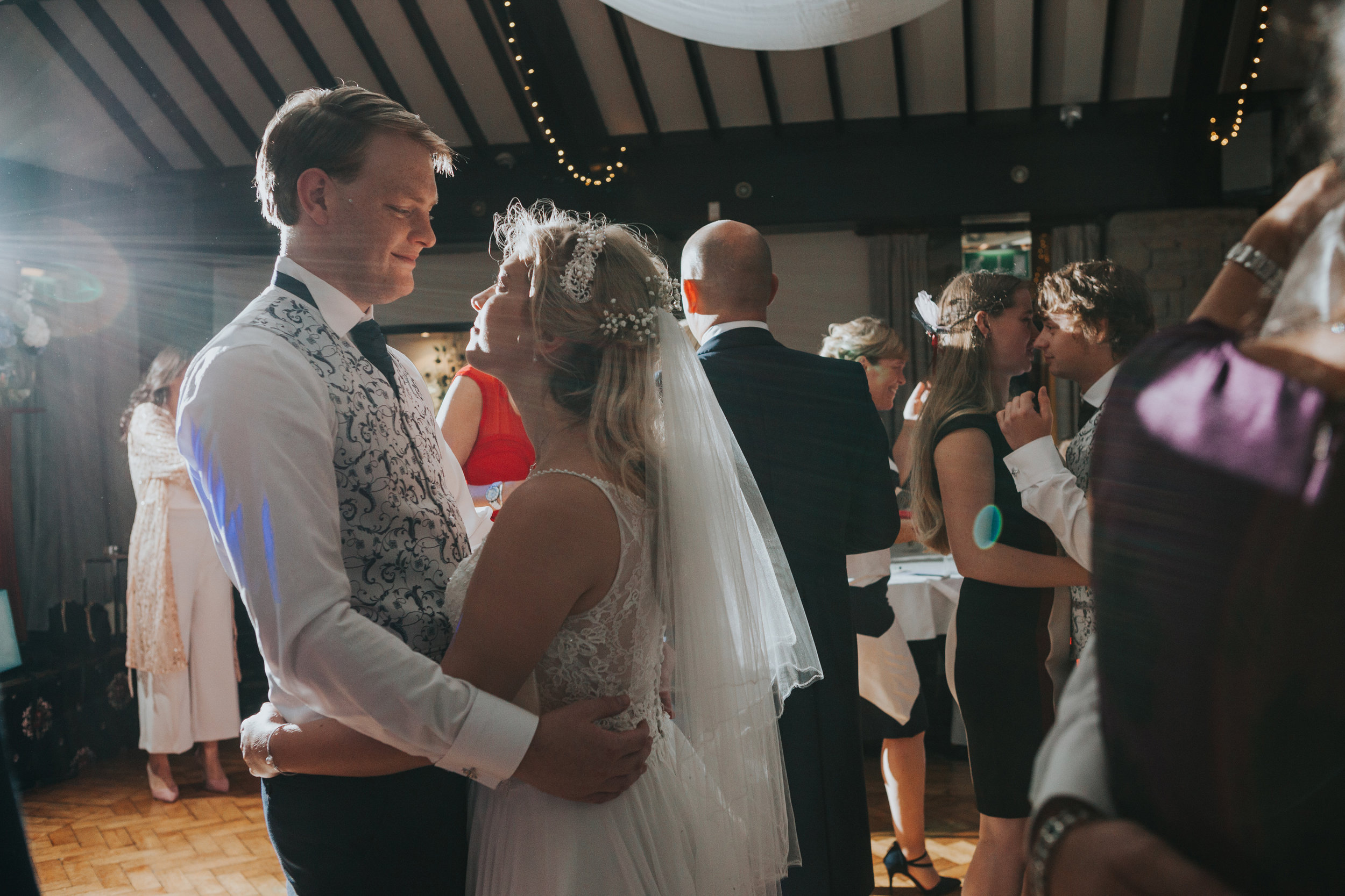 Bride and Groom look into each others eyes while dancing together.