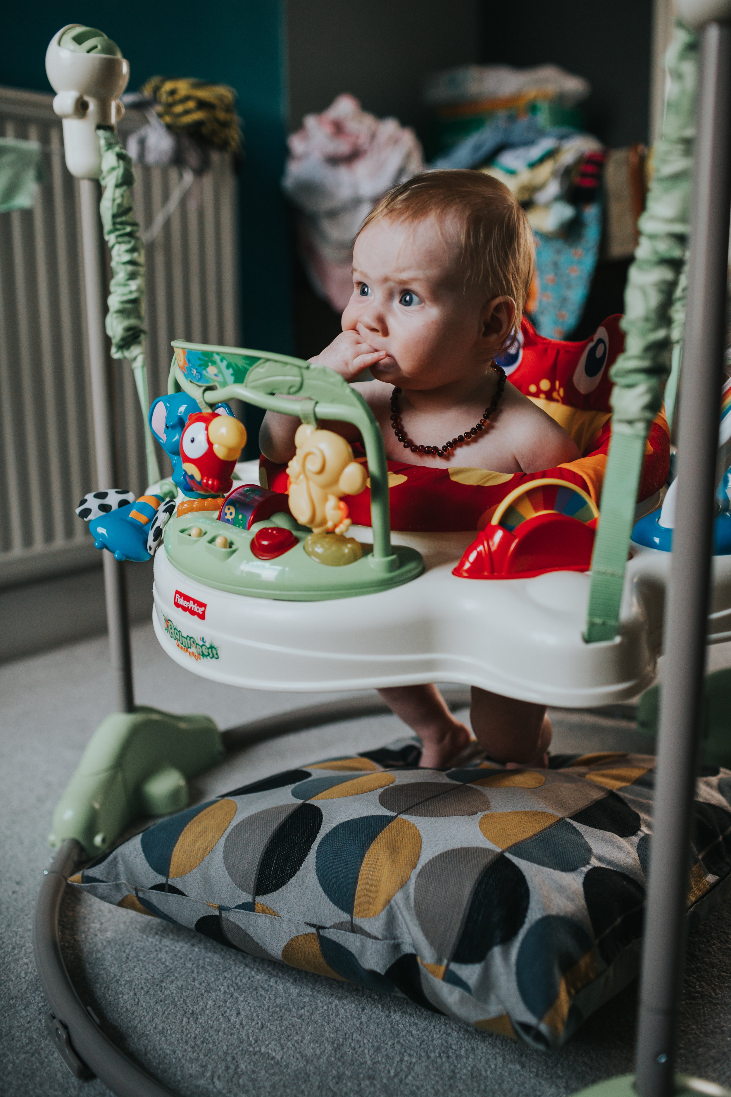 The baby sits in her walker she needs a cushion as her feet don't quite touch the floor yet. 