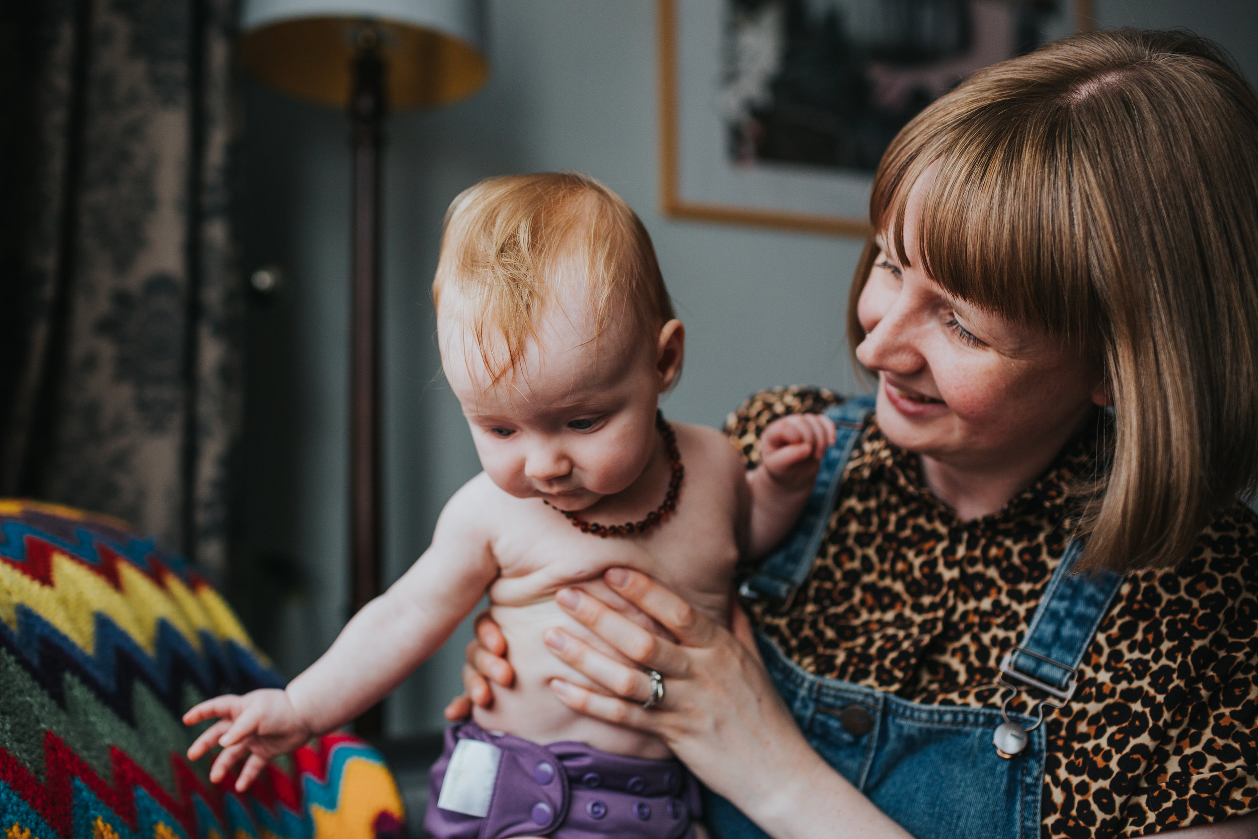 Mother and baby sit together at their home in Liverpool.