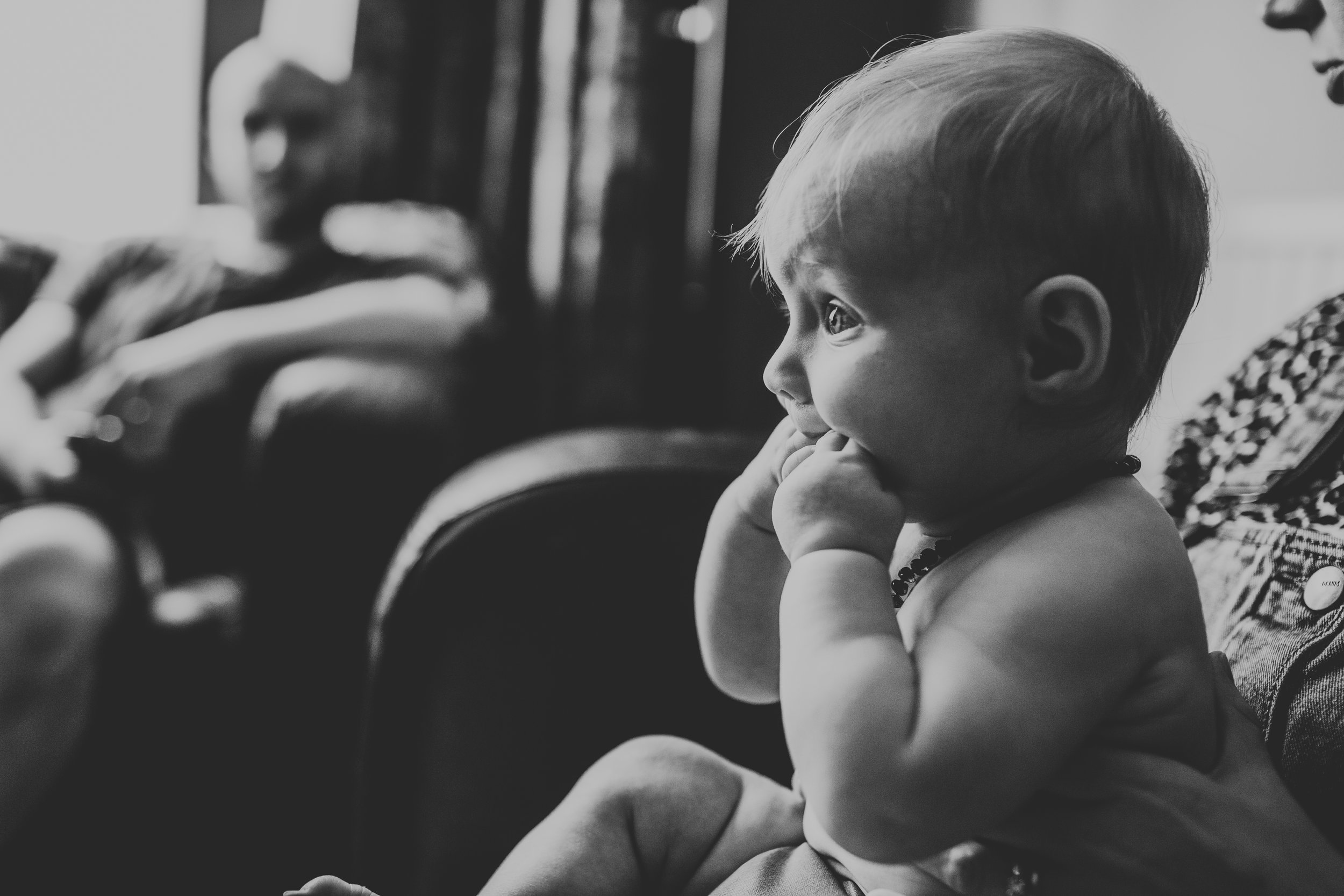 Baby watching formula one in black and white. 