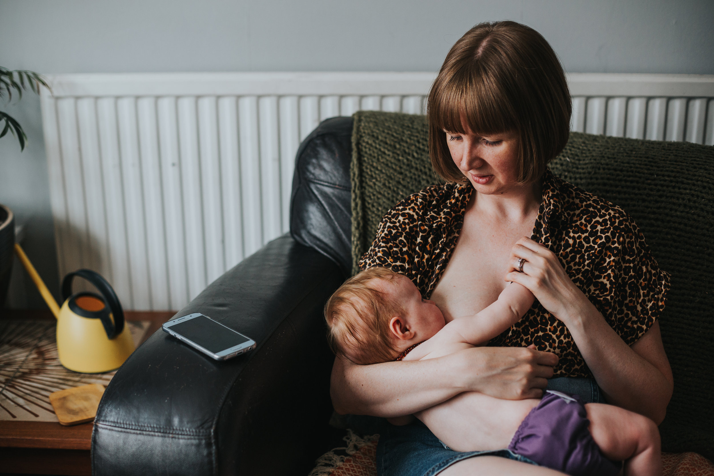 Mother breast feeds her baby girl at her home in Liverpool. 