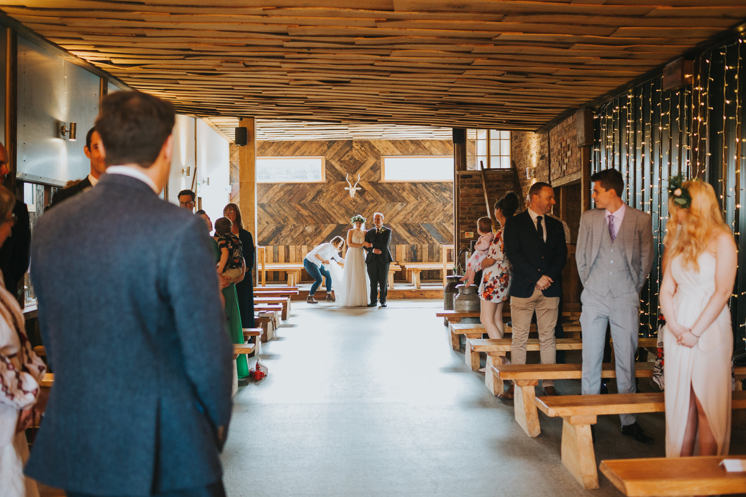 Bride stands with her father at the end of the aisle at Owen House Wedding Barn 