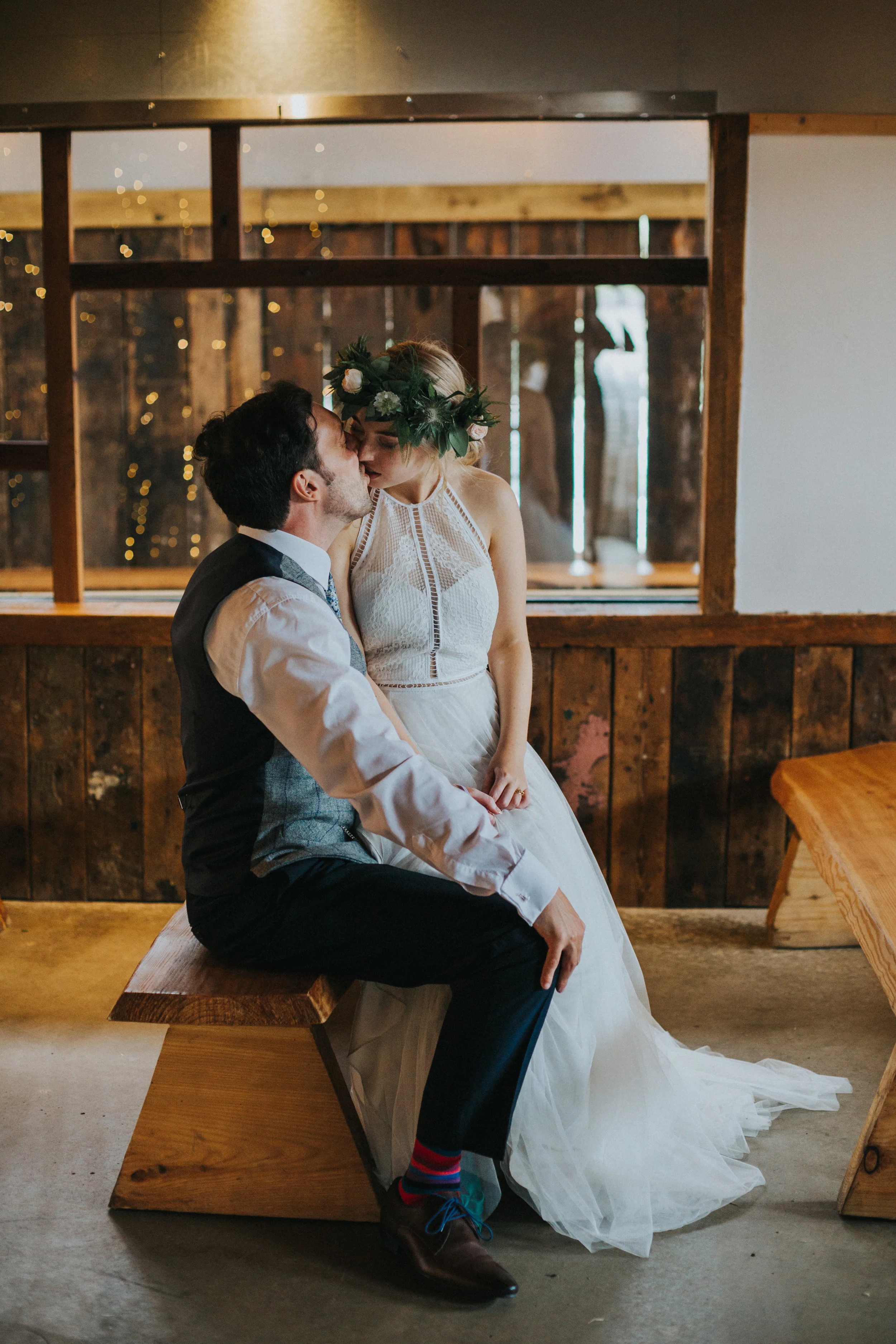 Bride and groom sneak away for a kiss in the room they were married. 