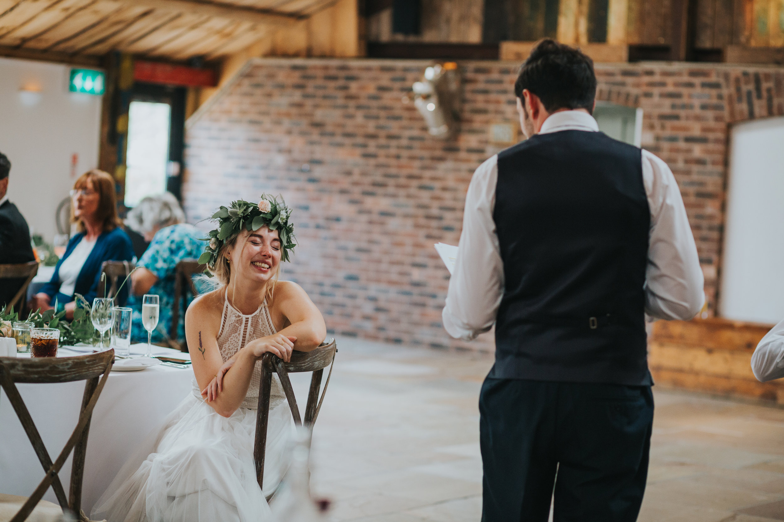 Bride laughs at her husbands speech.