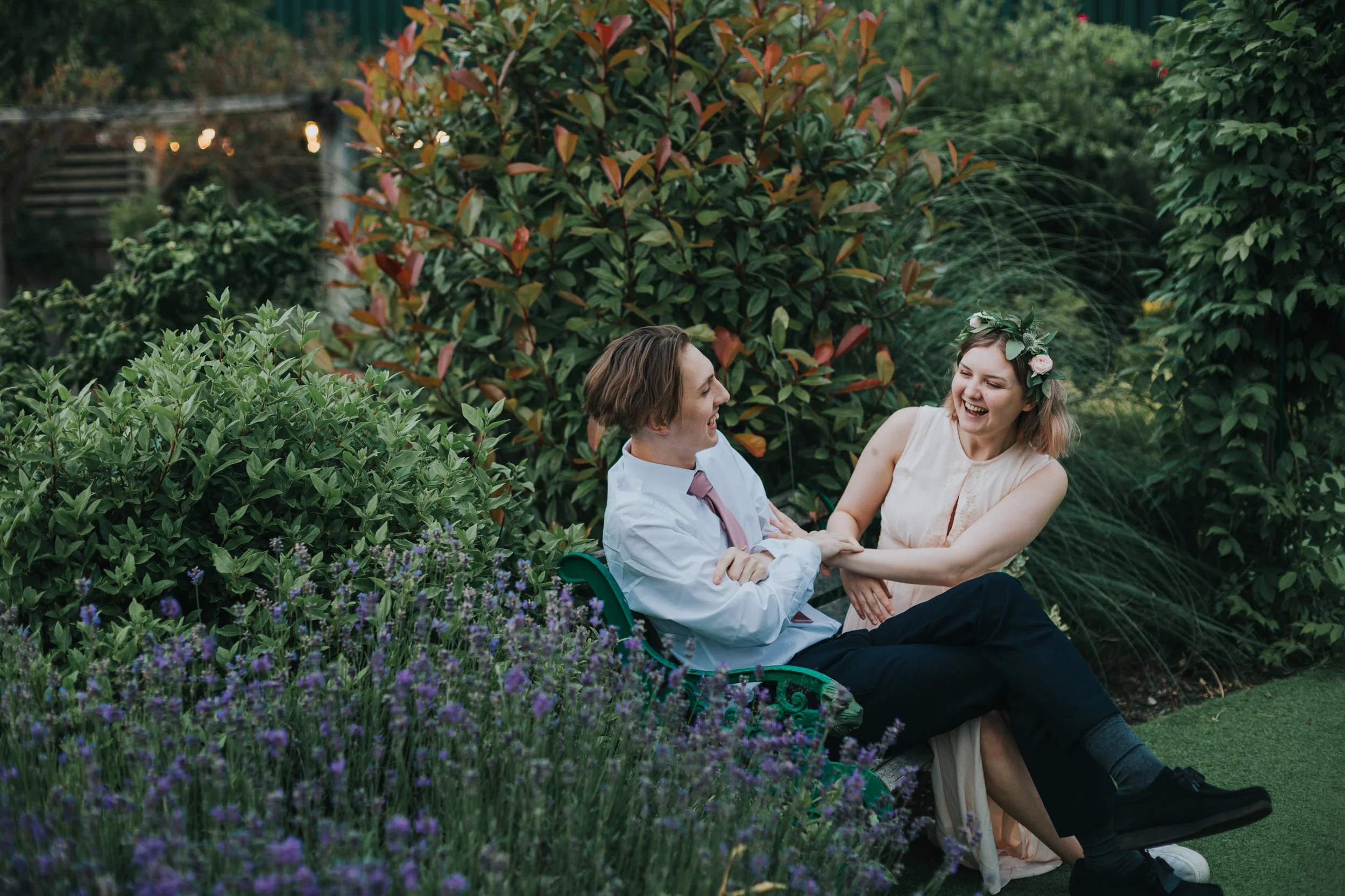 Bridesmaid and wedding guest laugh together. 