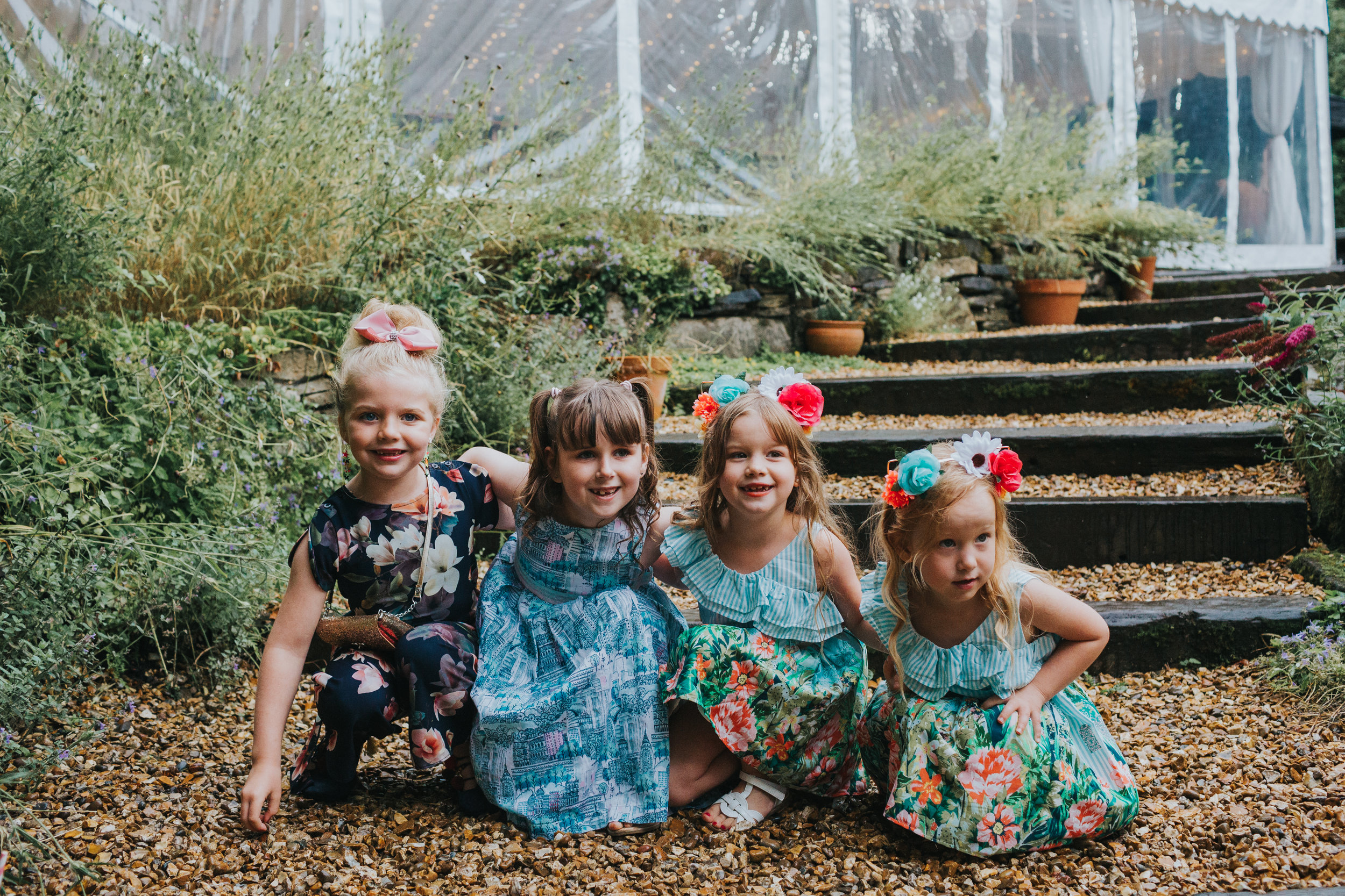 Four little girls crouch down on the floor together at Spring Cottage. 