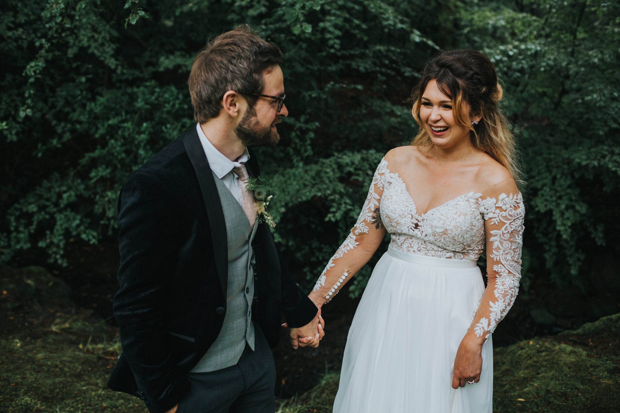 Bride laughing with groom in the woods. 