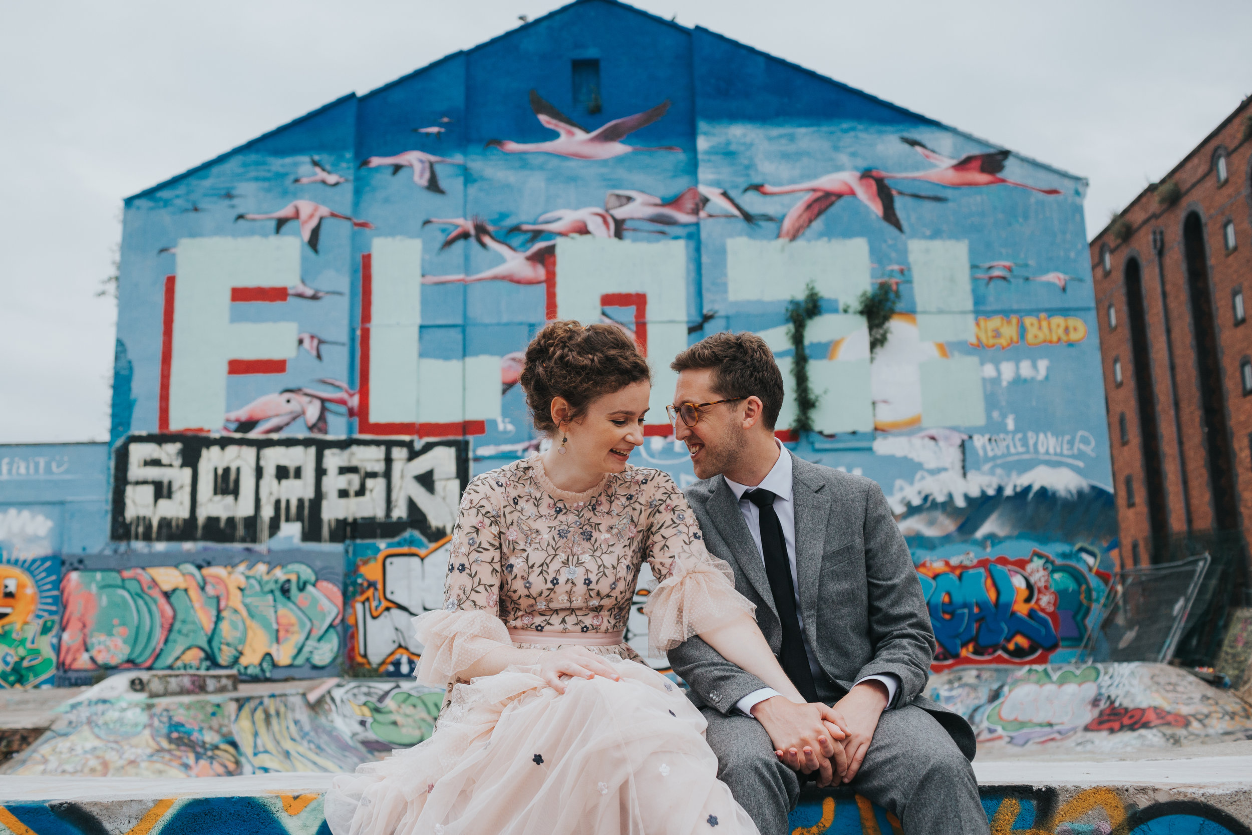 Bride and Groom take a quiet moment sitting together at the edge of the skate park. 