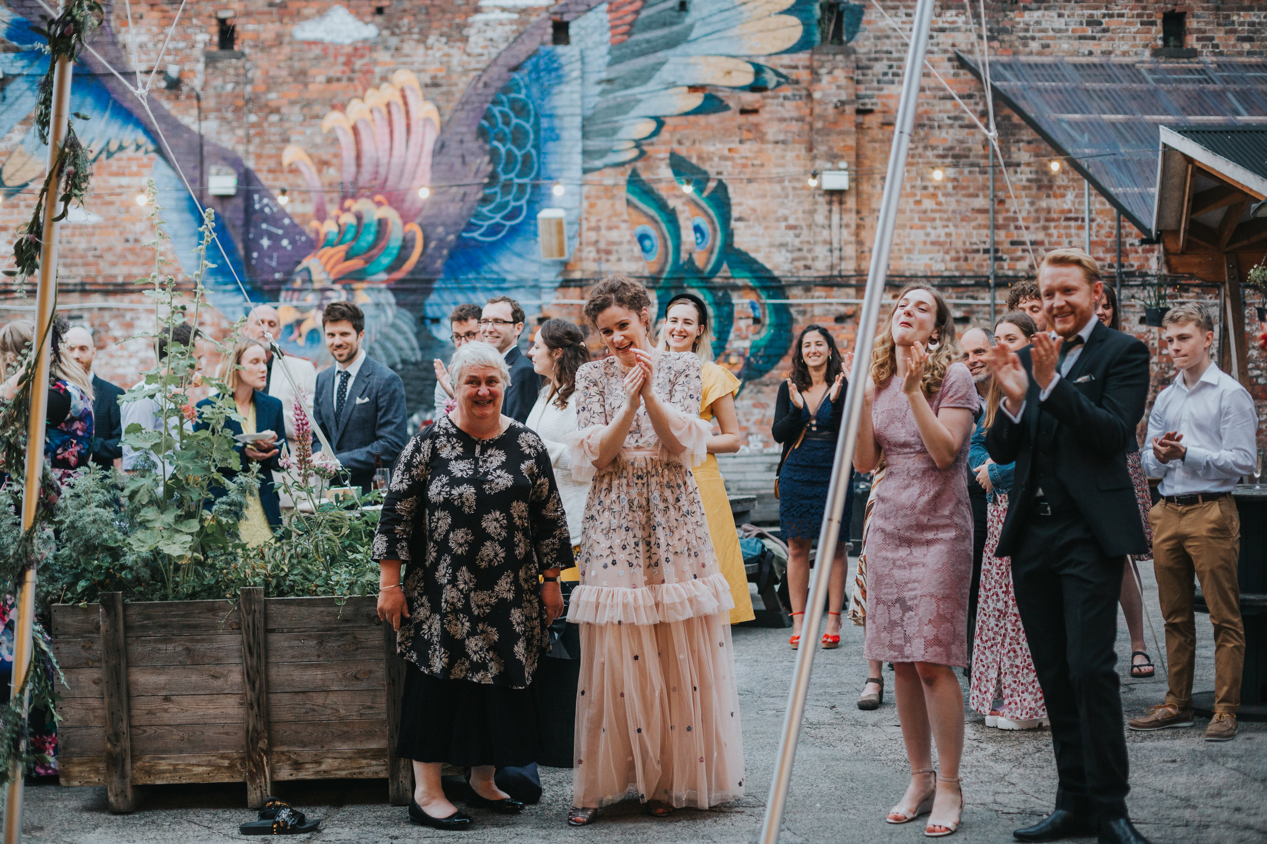 Bride and wedding guests applaud the grooms band.