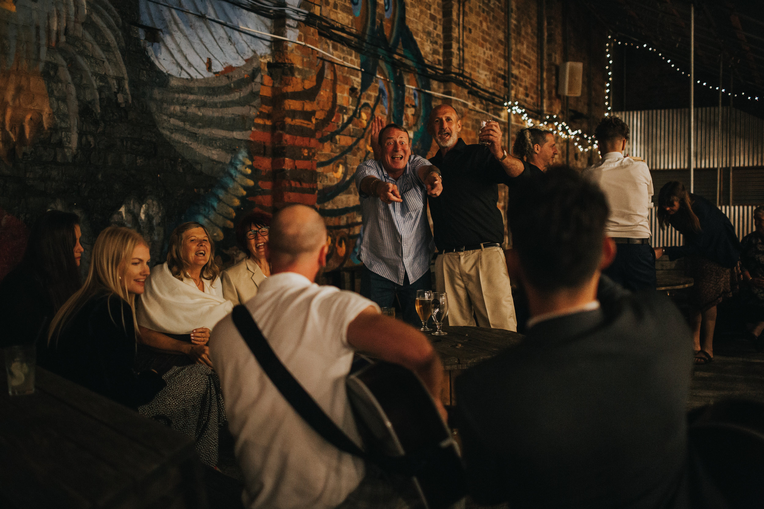 Guests sing along to the guitar.