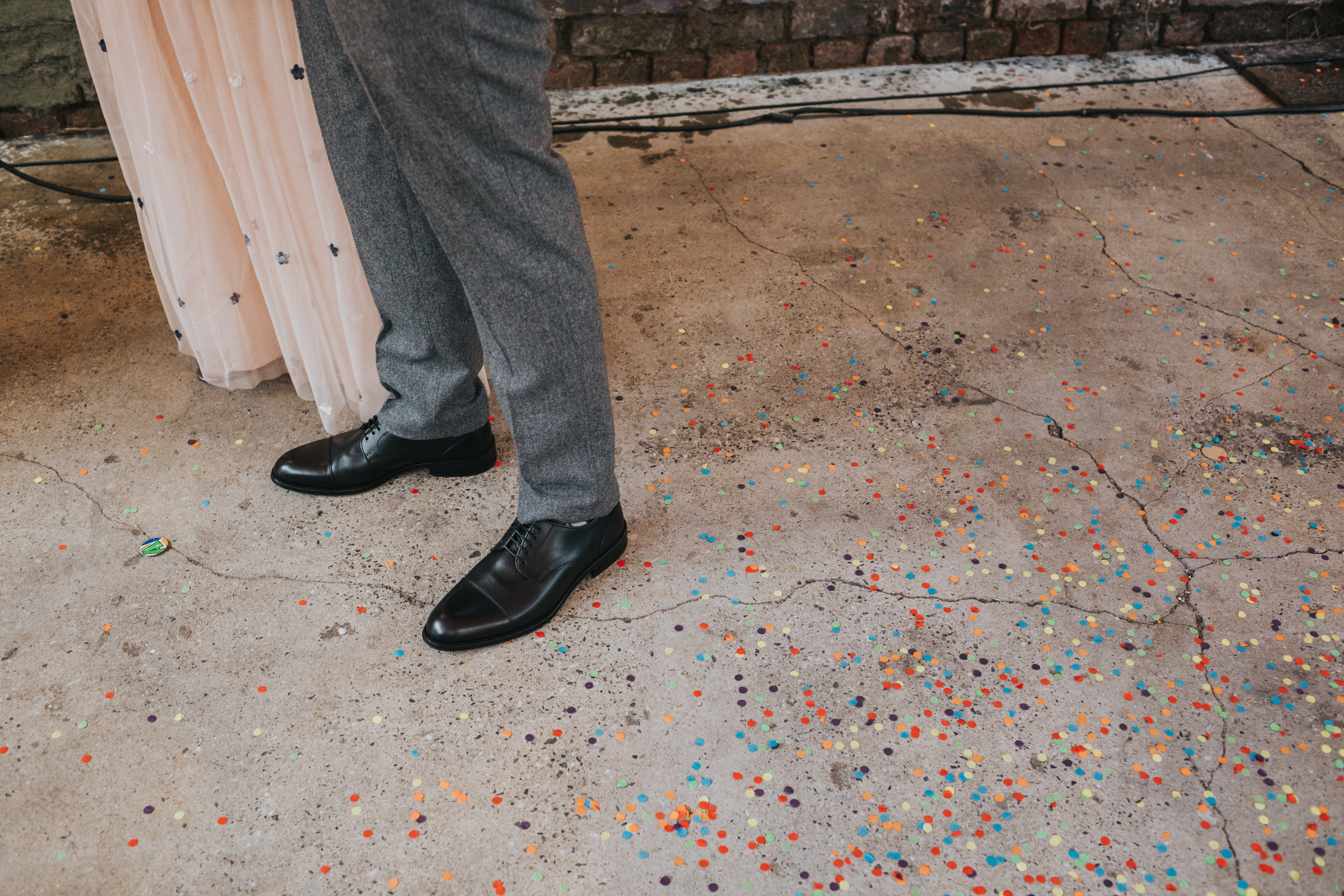 Bride and Grooms feet amongst colourful confetti. 