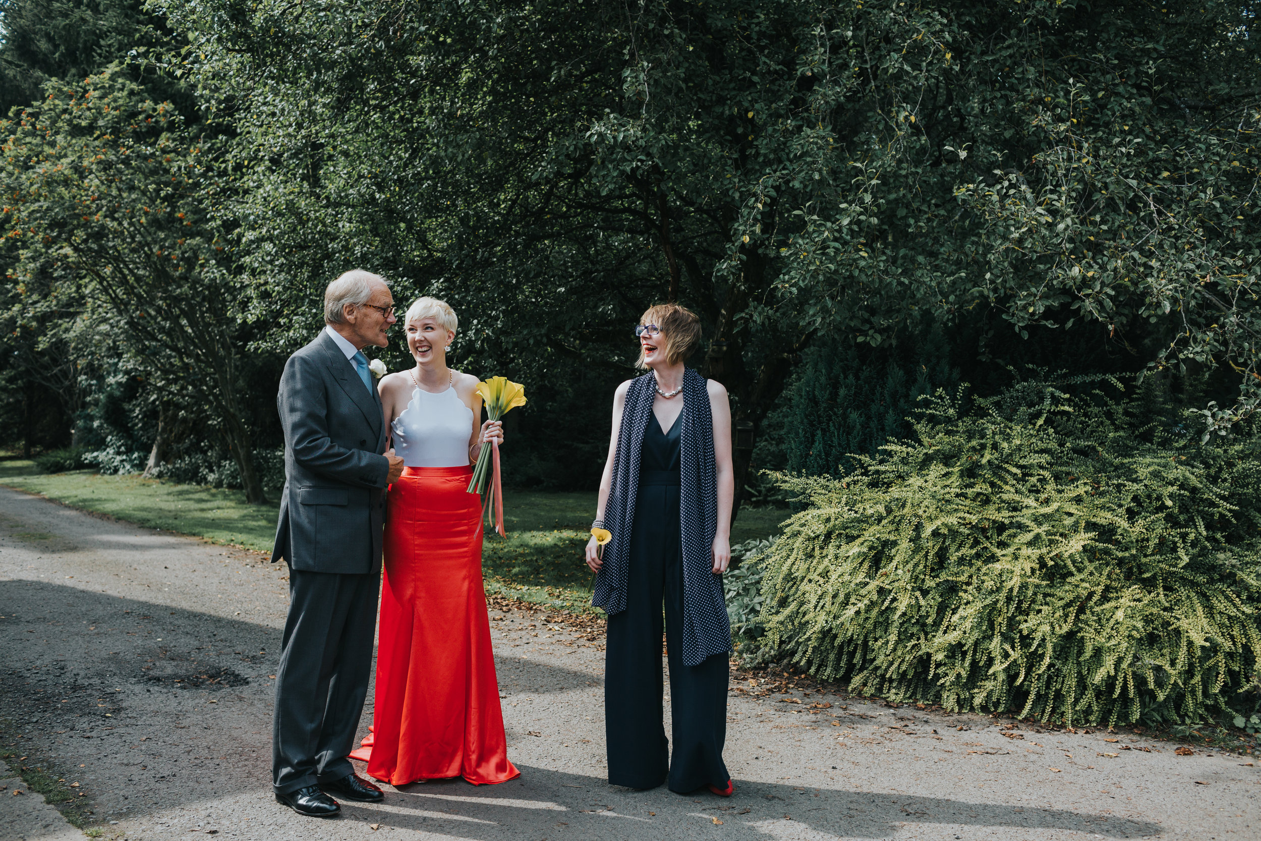 The bride is walked to the ceremony room by her father and best friend. 