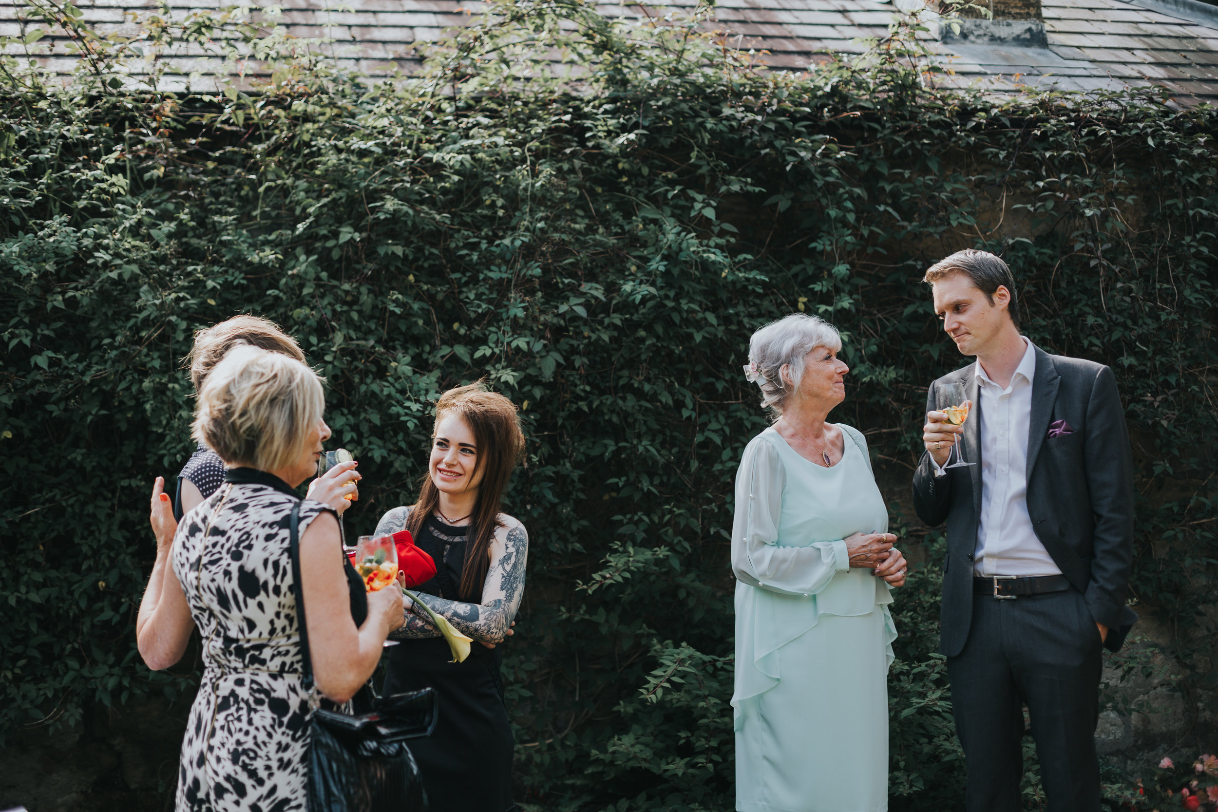 Mother of the bride has a moment with her son as the maid of honour and her partner chat with her mother. 