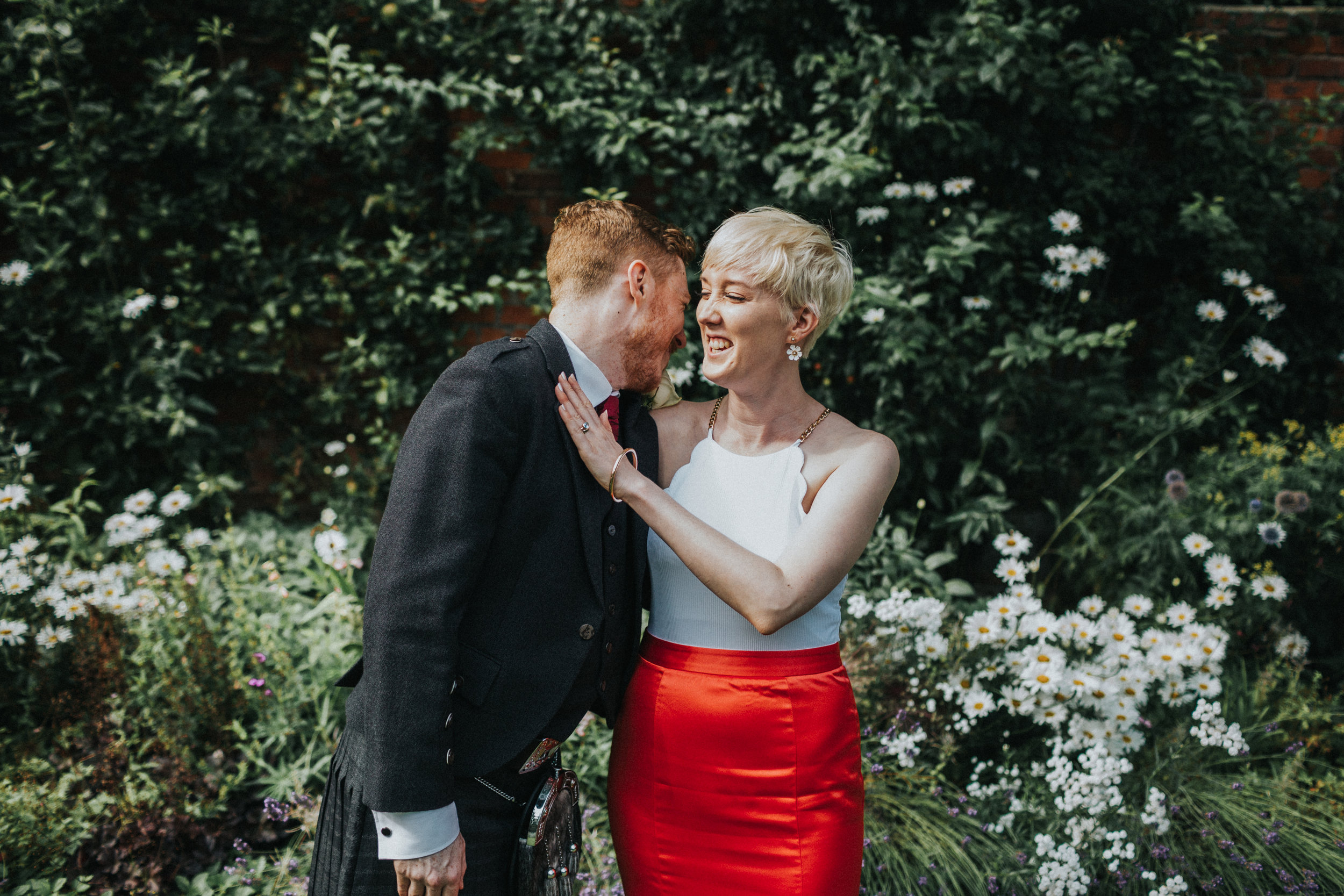 Groom cracks up laughing while bride gives him a shove. 