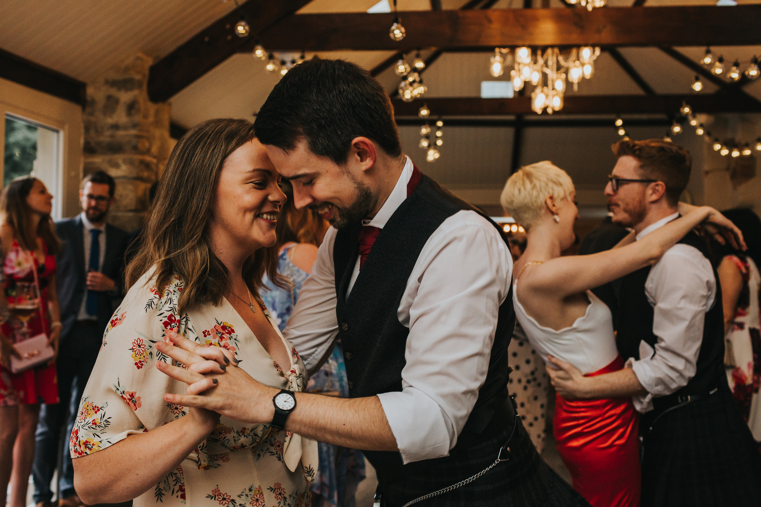 Wedding guests dance and smile.