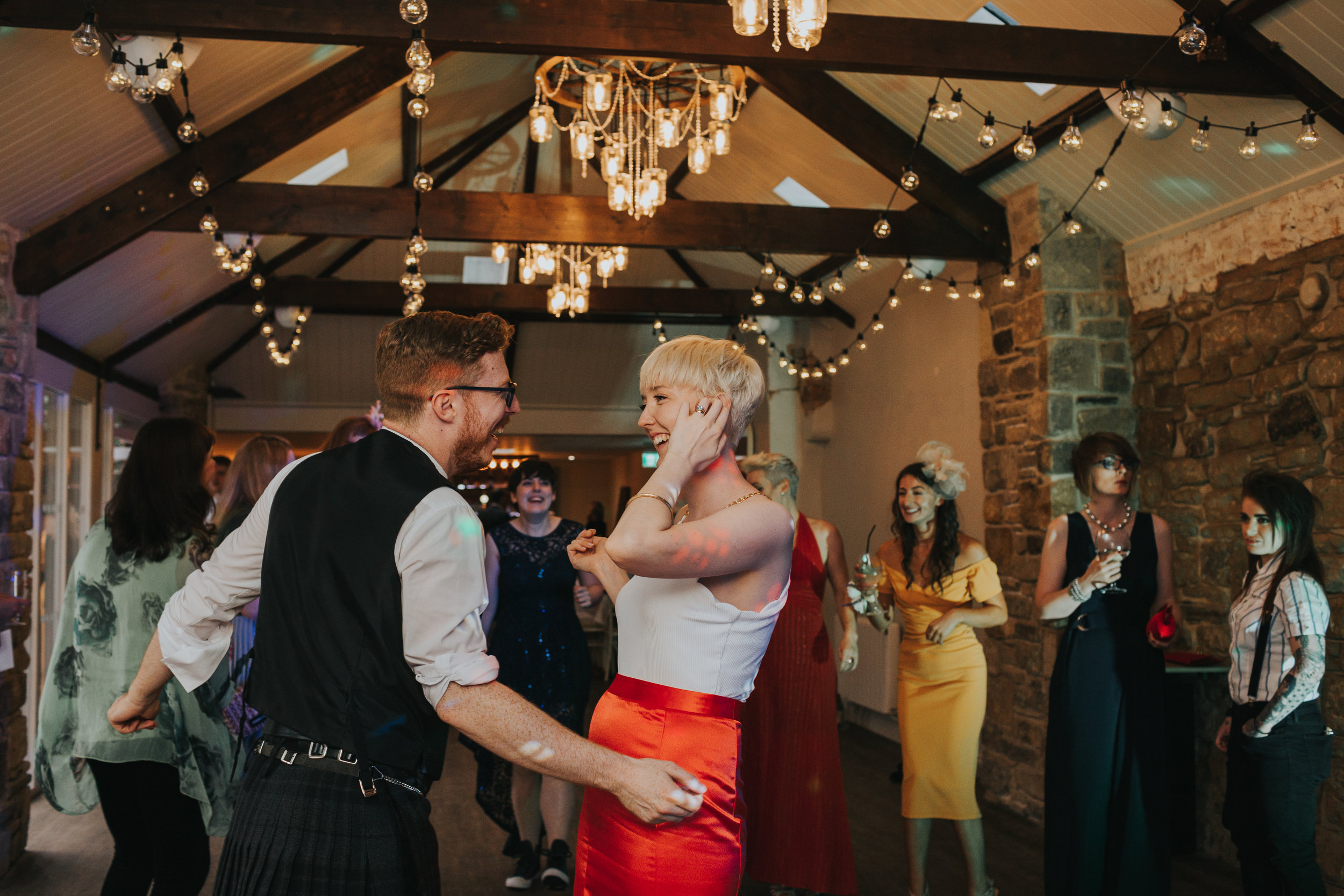 The bride and groom dance laughing together at Shotton Grange. 
