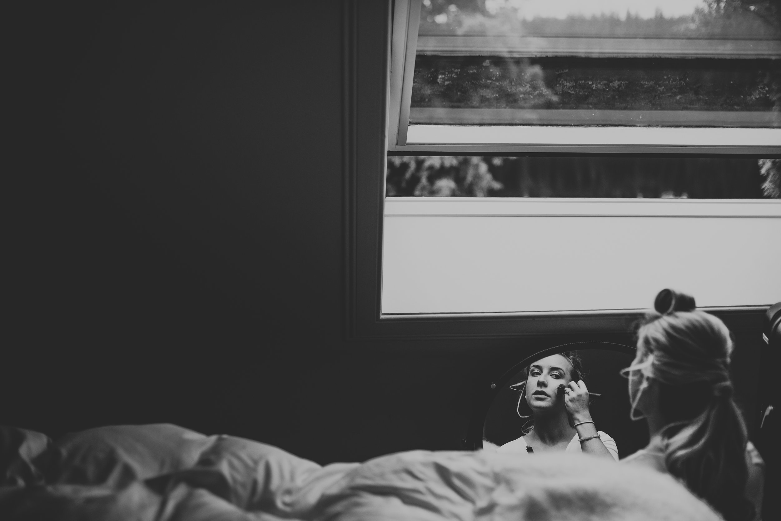 Wedding guest does her make up in mirror. Photo in black and white. 